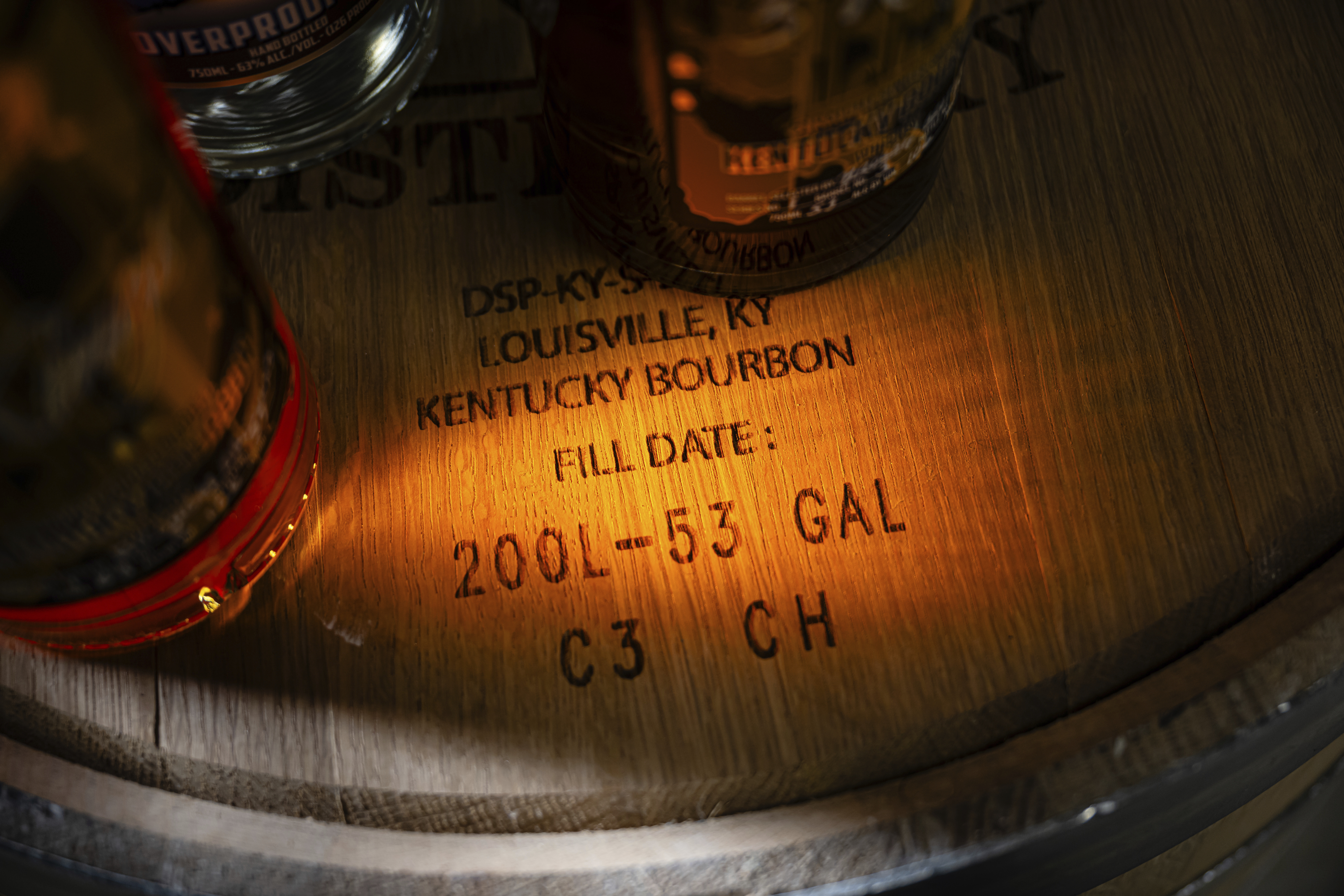 Labeling on the head of a bourbon barrel is seen near bottles of product at the Brough Brothers Distillery which is under construction in Louisville, Ky., Saturday, March 8, 2025. (AP Photo/Jon Cherry)