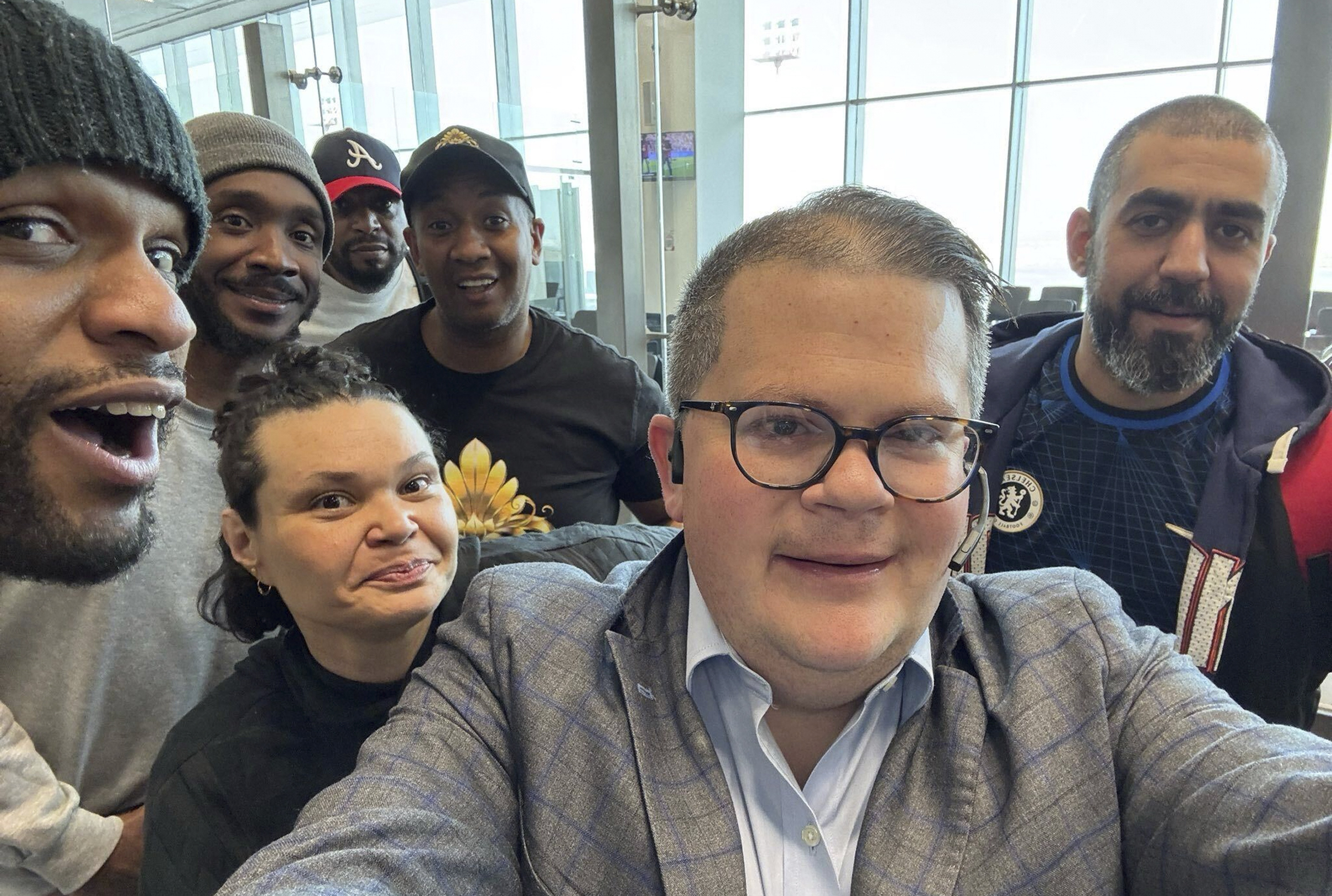 This image provided by Jonathan Franks shows Franks with six American prisoners detained by Kuwait as they pose for a photo at Kuwait International Airport Wednesday, March 12, 2025, before flying home to the United States. Franks is a private consultant who helped work for their release. (Jonathan Franks via AP)