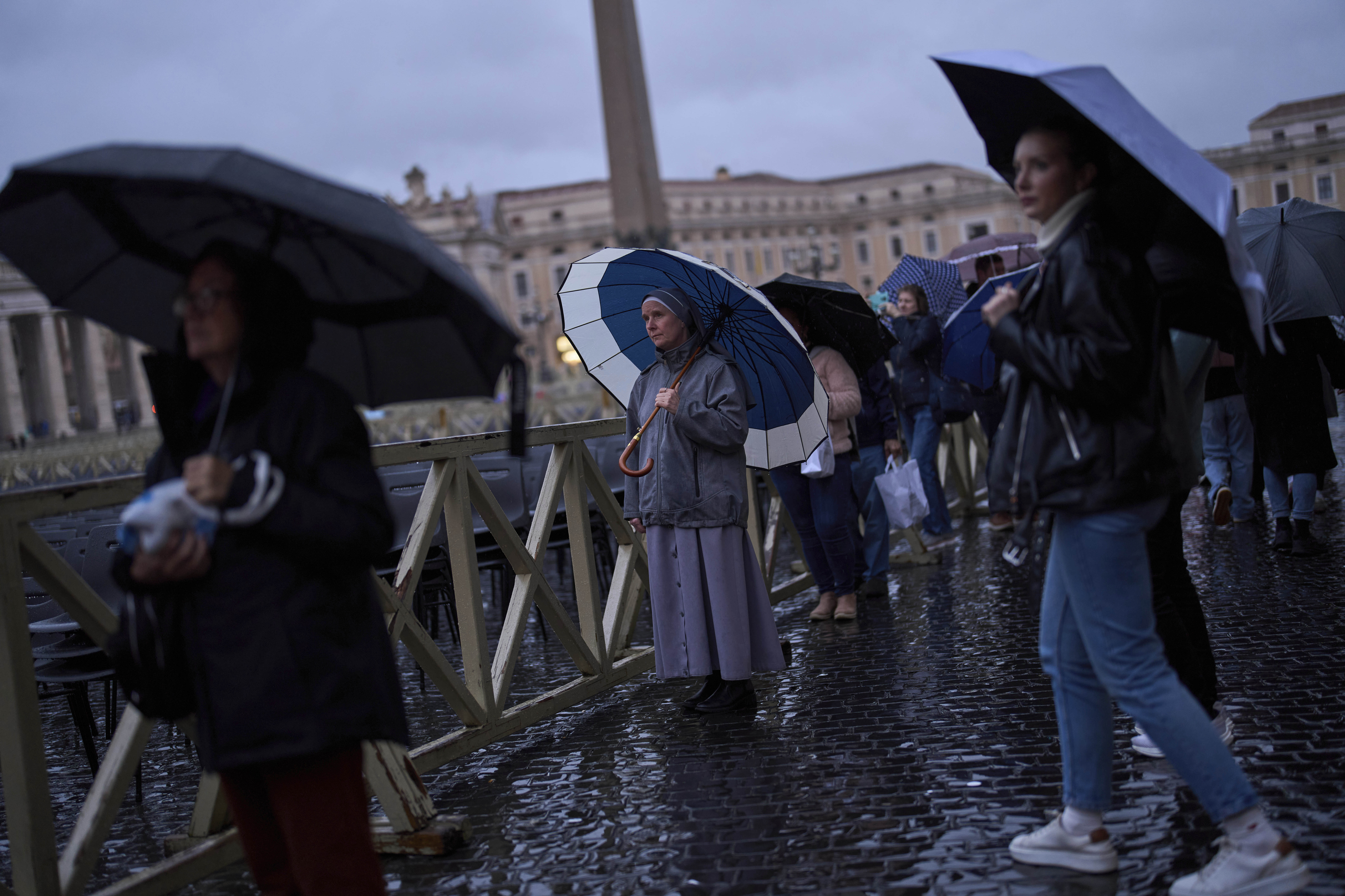 People pray as they follow a live broadcasted Rosary prayer for Pope Francis, in St. Peter's Square at the Vatican, Wednesday, March 12, 2025. (AP Photo/Francisco Seco)