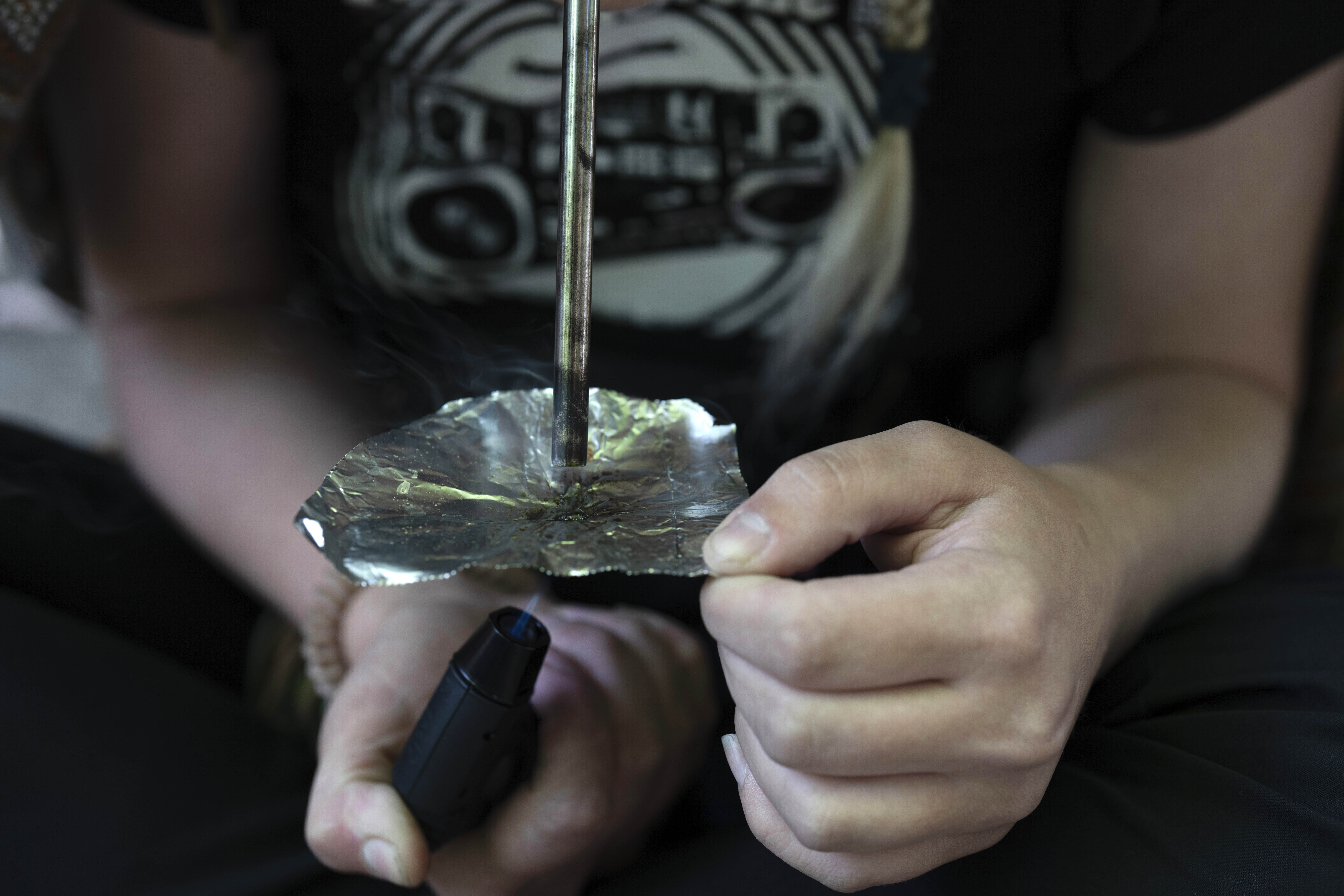 FILE - A homeless woman smokes fentanyl in a park June 28, 2024, in downtown Portland, Ore. (AP Photo/Jenny Kane, File)