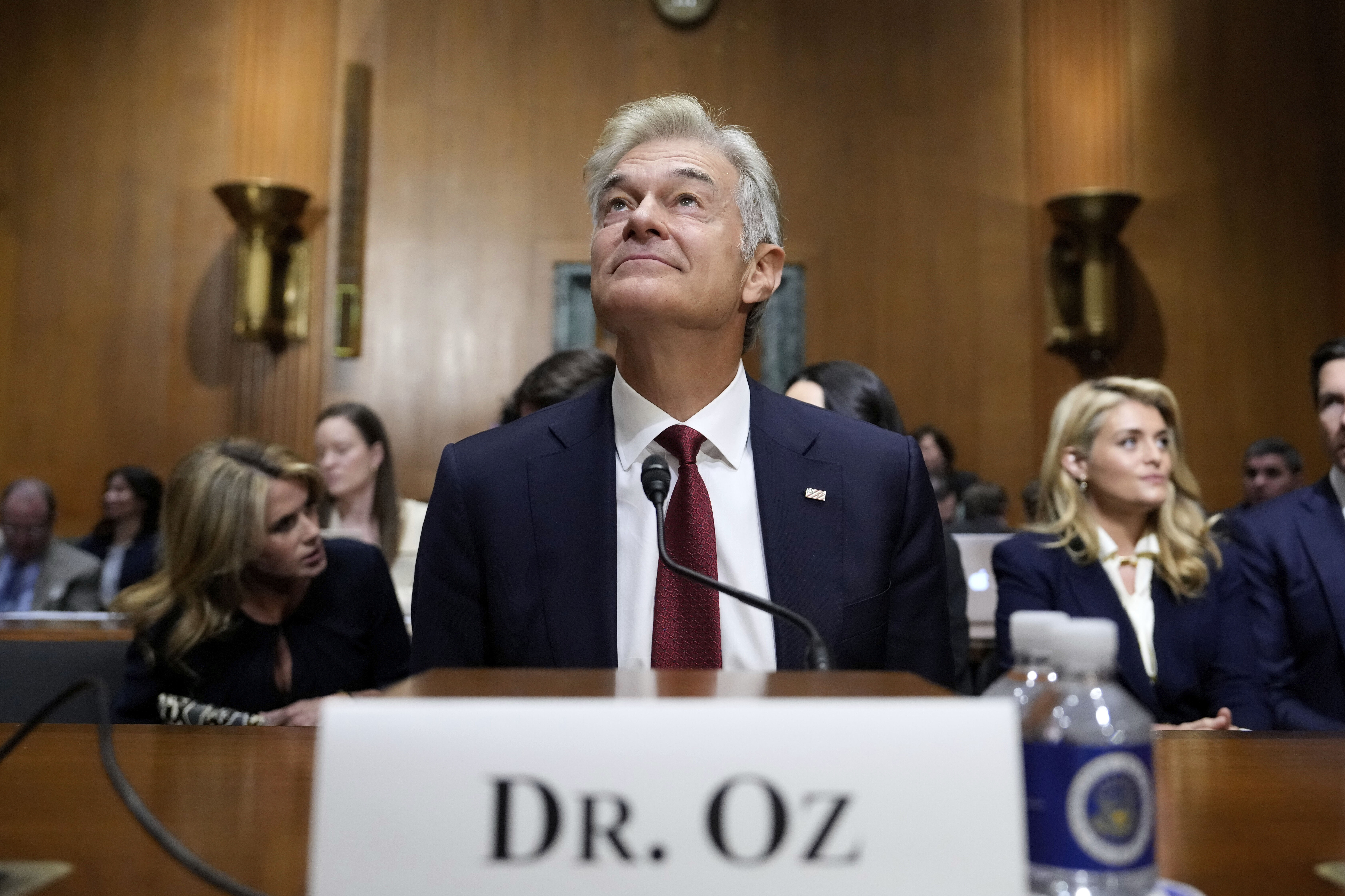 Dr. Mehmet Oz, President Donald Trump's pick to lead the Centers for Medicare and Medicaid Services, joined by wife Lisa Oz, left, and daughter Daphne Oz, right, sits before testifying at his confirmation hearing before the Senate Finance Committee, on Capitol Hill in Washington, Friday, March 14, 2025. (AP Photo/Ben Curtis)