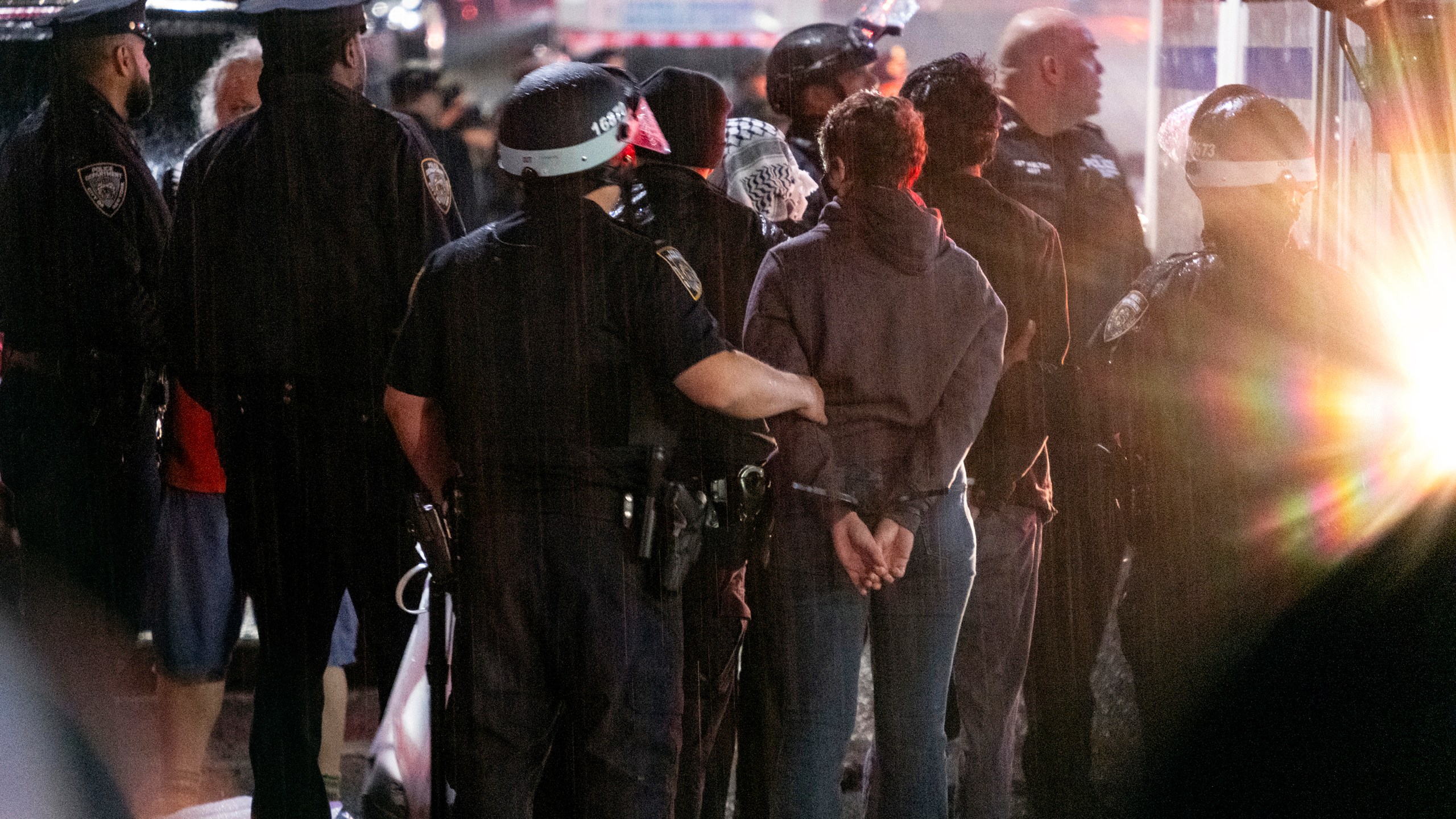 FILE - As light rain falls, New York City police officers take people into custody near the Columbia University campus in New York, Tuesday, April 30, 2024, after a building taken over by pro-Palestinian protesters earlier in the day was cleared, along with a tent encampment. (AP Photo/Craig Ruttle, File)