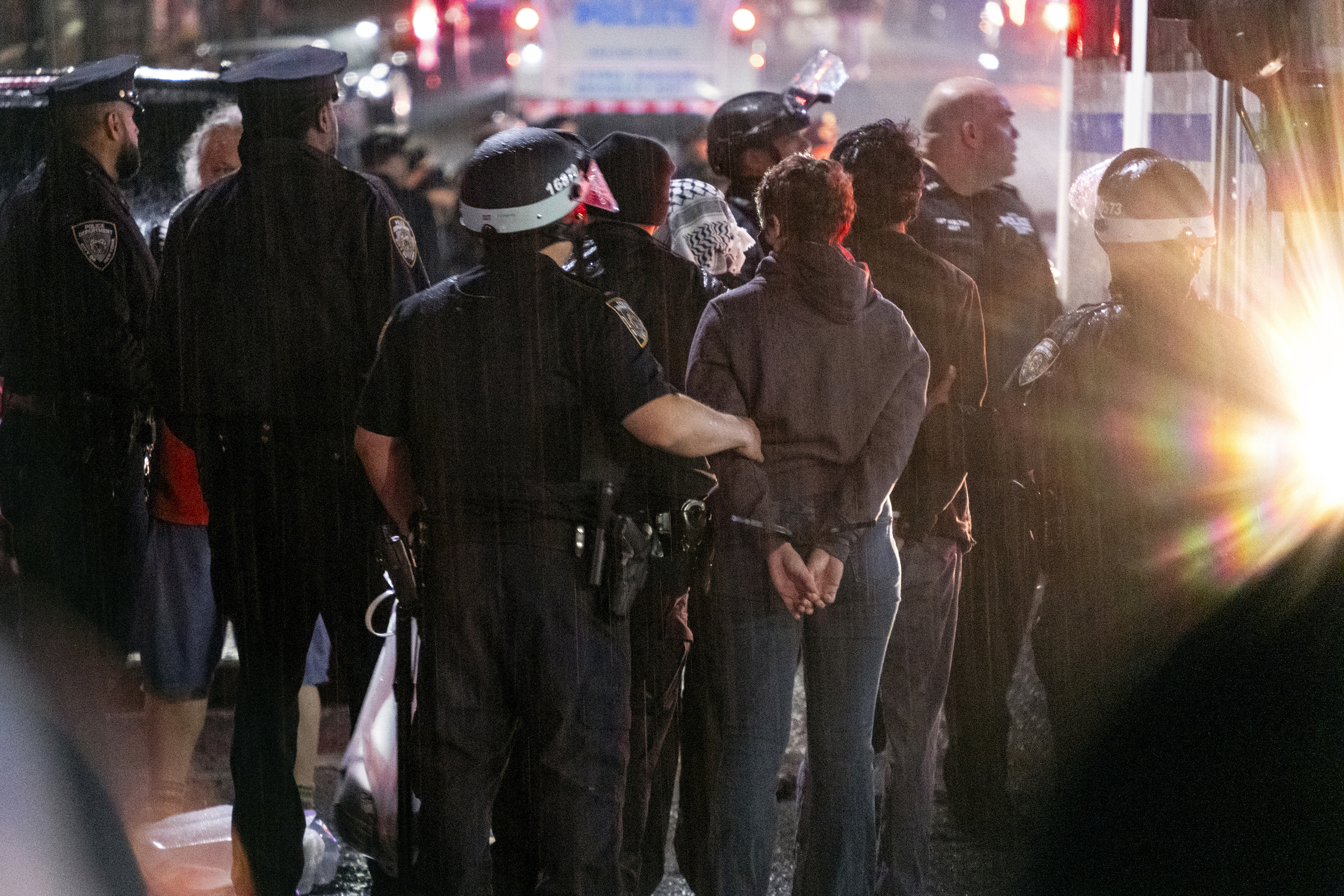 FILE - As light rain falls, New York City police officers take people into custody near the Columbia University campus in New York, Tuesday, April 30, 2024, after a building taken over by pro-Palestinian protesters earlier in the day was cleared, along with a tent encampment. (AP Photo/Craig Ruttle, File)