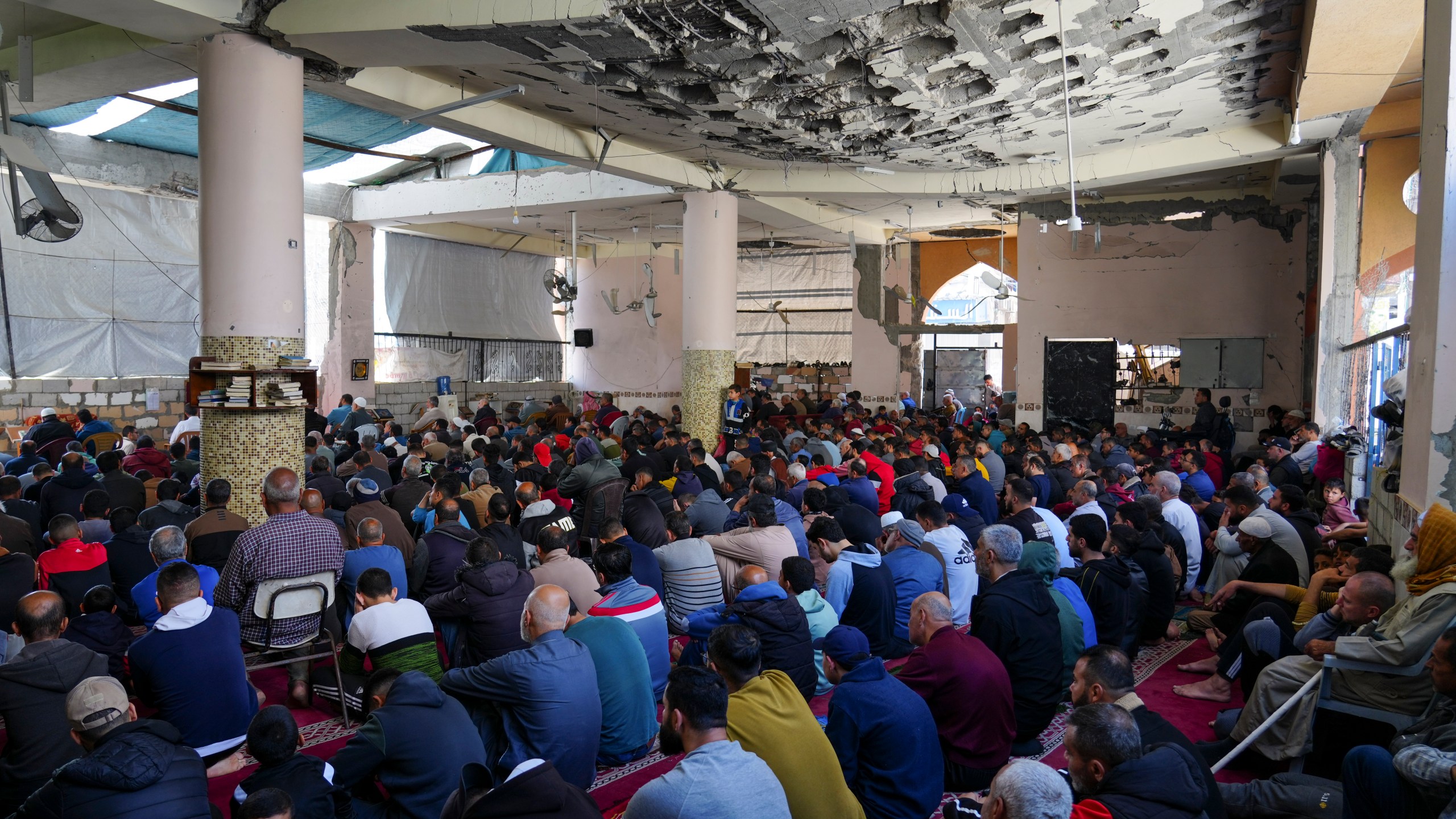 Palestinians take part in Friday prayers in the ruins of a Mosque that was partially destroyed by Israeli bombardment, in Nuseirat, Gaza Strip, Friday, March 14, 2025, during the holy Muslim month of Ramadan. (AP Photo/Abdel Kareem Hana)