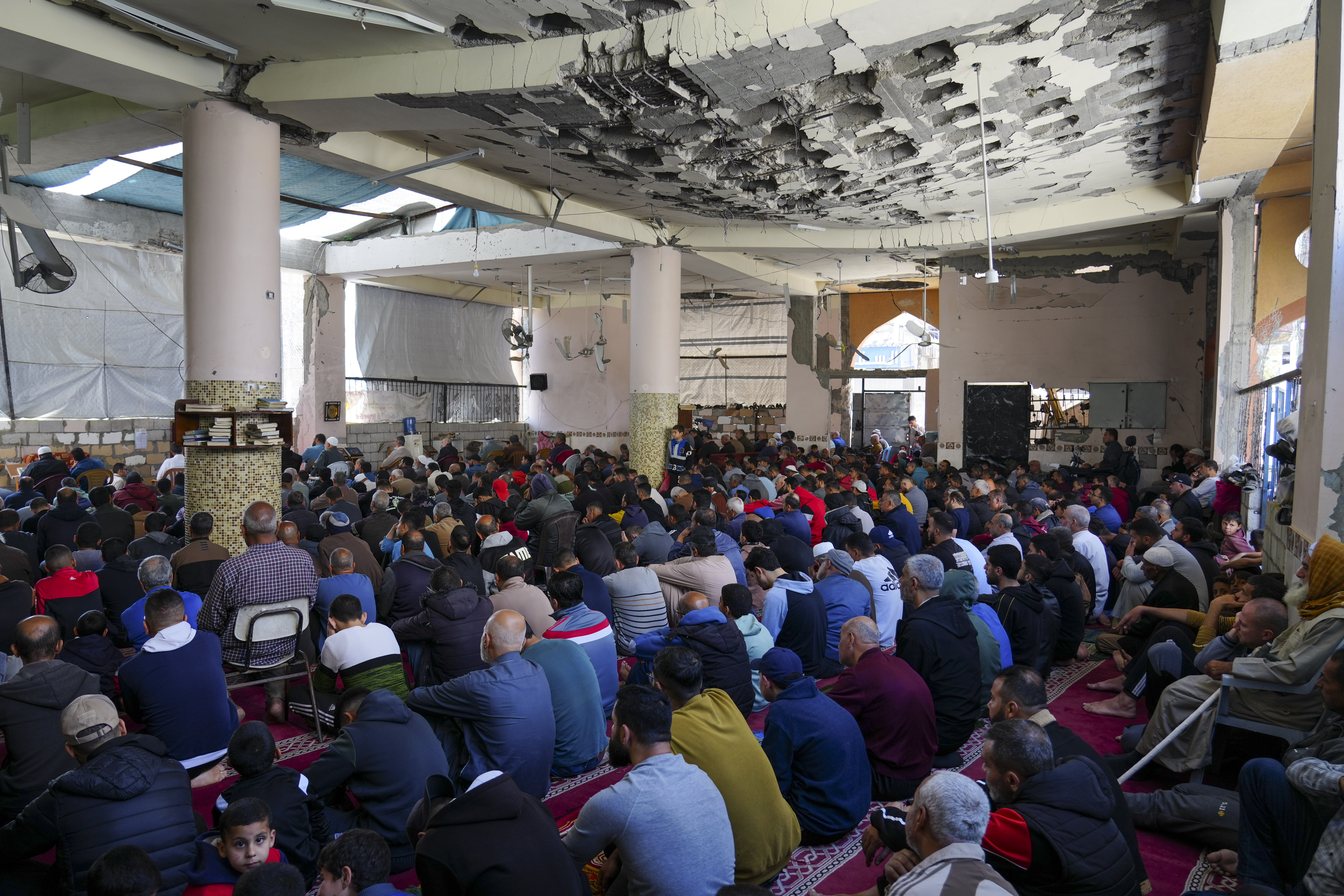 Palestinians take part in Friday prayers in the ruins of a Mosque that was partially destroyed by Israeli bombardment, in Nuseirat, Gaza Strip, Friday, March 14, 2025, during the holy Muslim month of Ramadan. (AP Photo/Abdel Kareem Hana)