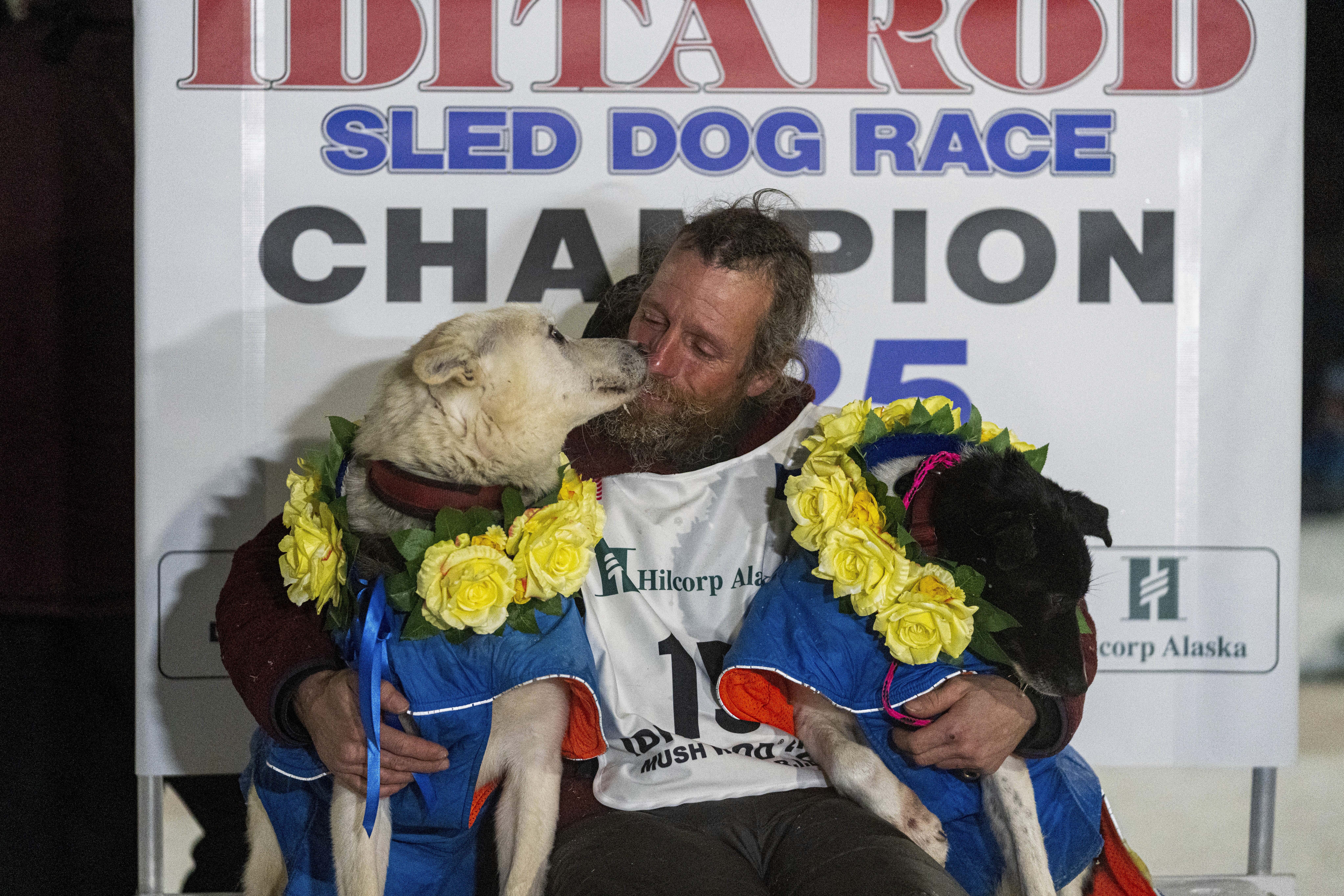 Jessie Holmes hugs his lead dogs Polar, left, and Hercules after winning the Iditarod Trail Sled Dog Race early Friday morning, March 14, 2025 in Nome. (Loren Holme/Anchorage Daily News via AP)