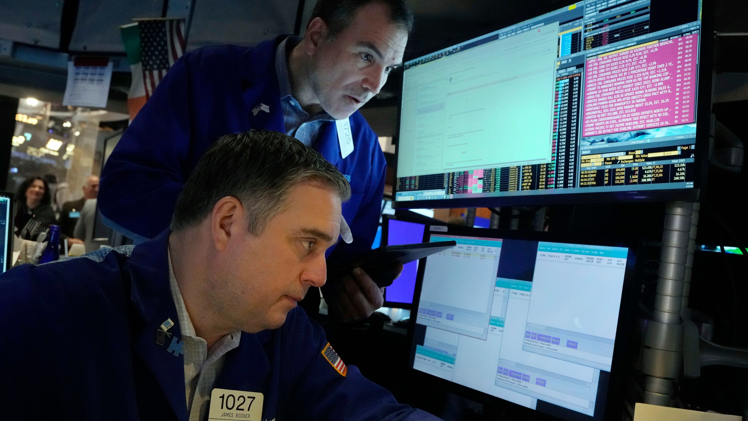 A pair of traders work on the floor of the New York Stock Exchange, Wednesday, March 12, 2025. (AP Photo/Richard Drew)