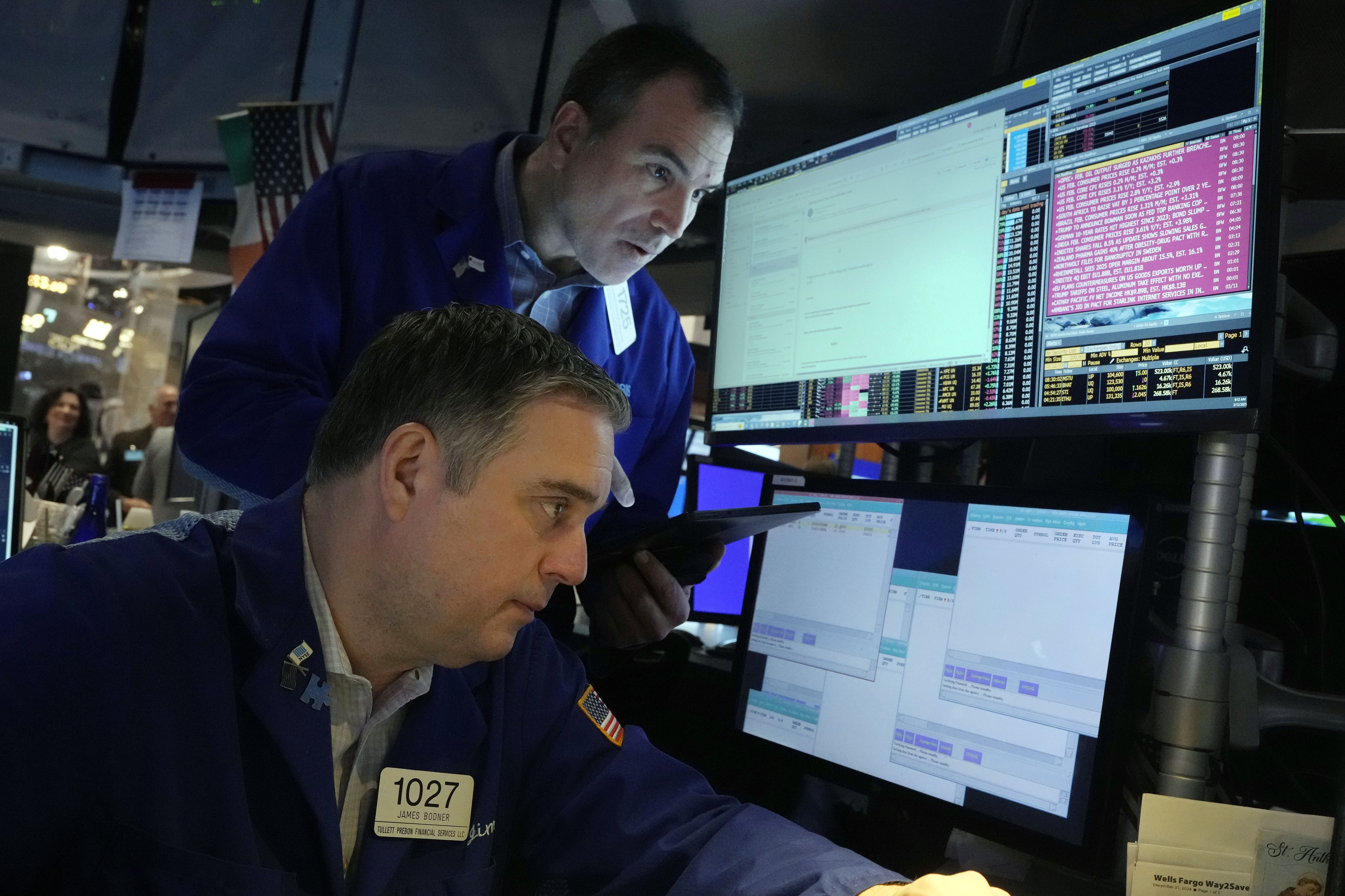 A pair of traders work on the floor of the New York Stock Exchange, Wednesday, March 12, 2025. (AP Photo/Richard Drew)