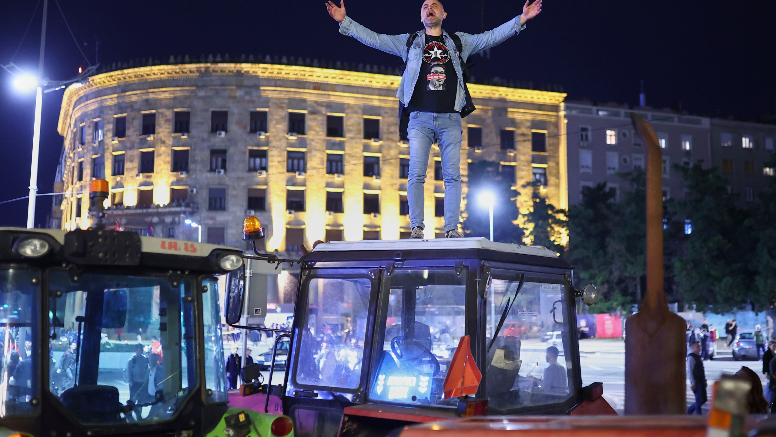 A protester yells from the top of a tractor ahead of a major rally this weekend in downtown Belgrade, Serbia, Friday, March 14, 2025. (AP Photo/Armin Durgut)