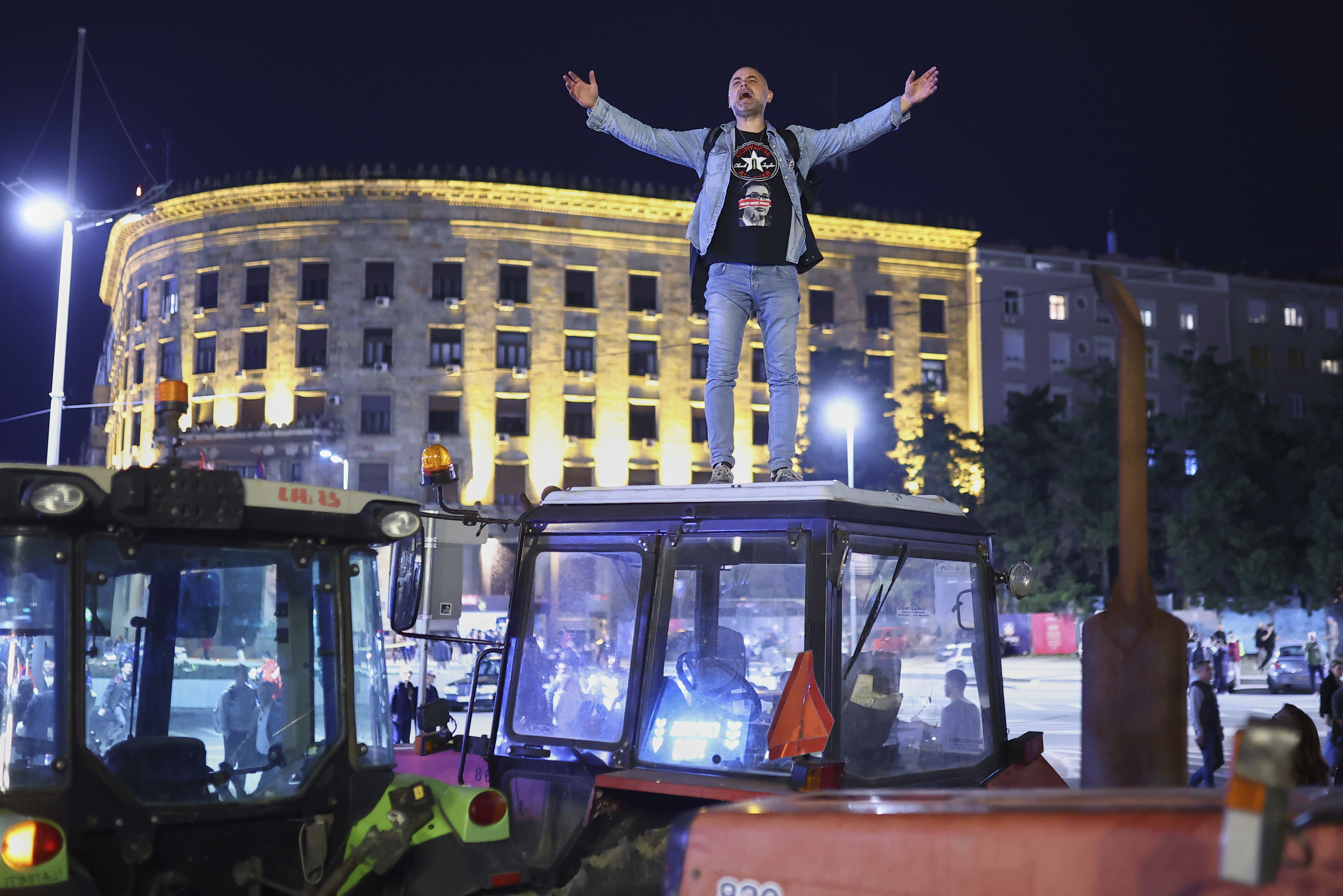 A protester yells from the top of a tractor ahead of a major rally this weekend in downtown Belgrade, Serbia, Friday, March 14, 2025. (AP Photo/Armin Durgut)