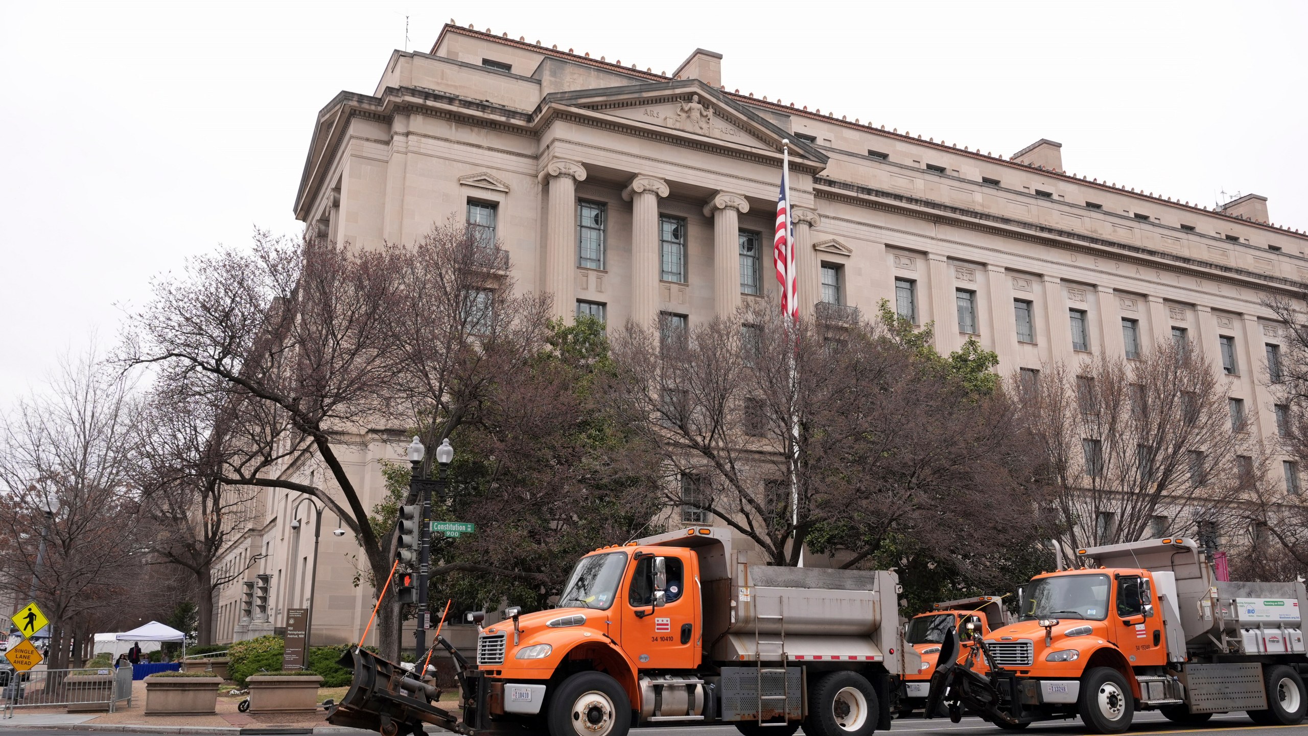 Trucks providing a security barrier are in place around the Department of Justice before President Donald Trump speaks Friday, March 14, 2025, in Washington. (AP Photo/Jacquelyn Martin)