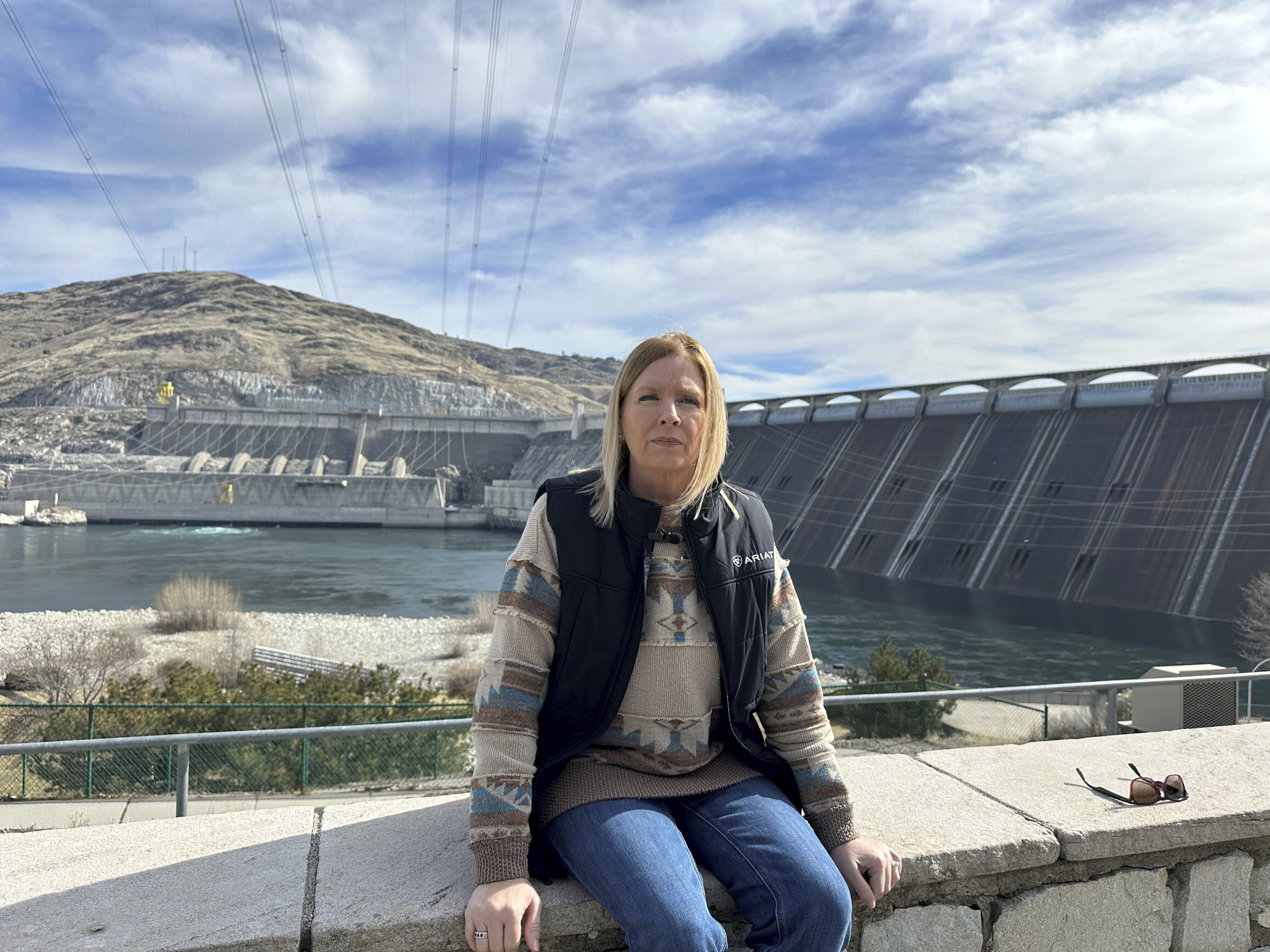 Former Grand Coulee Dam worker, Stephanie Duclos, sits in front of the Grand Coulee Dam on Friday, Feb. 28, 2025 in Coulee Dam, Wash., explaining how she was terminated from her job under the Trump administration’s federal workforce reduction plan. (AP Photo/Martha Bellisle)