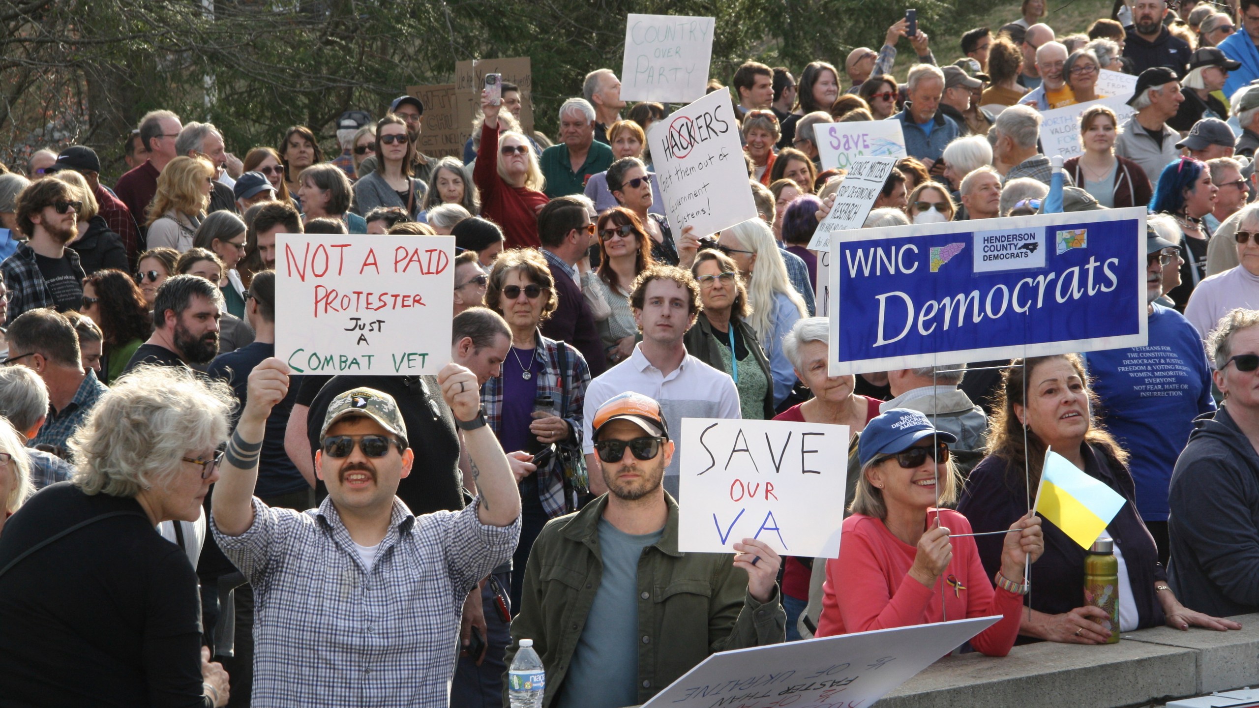 Protesters show up with signs to a town hall held by Rep. Chuck Edwards in Asheville, N.C. on Thursday, March 13, 2025. (AP Photo/Makiya Seminera)