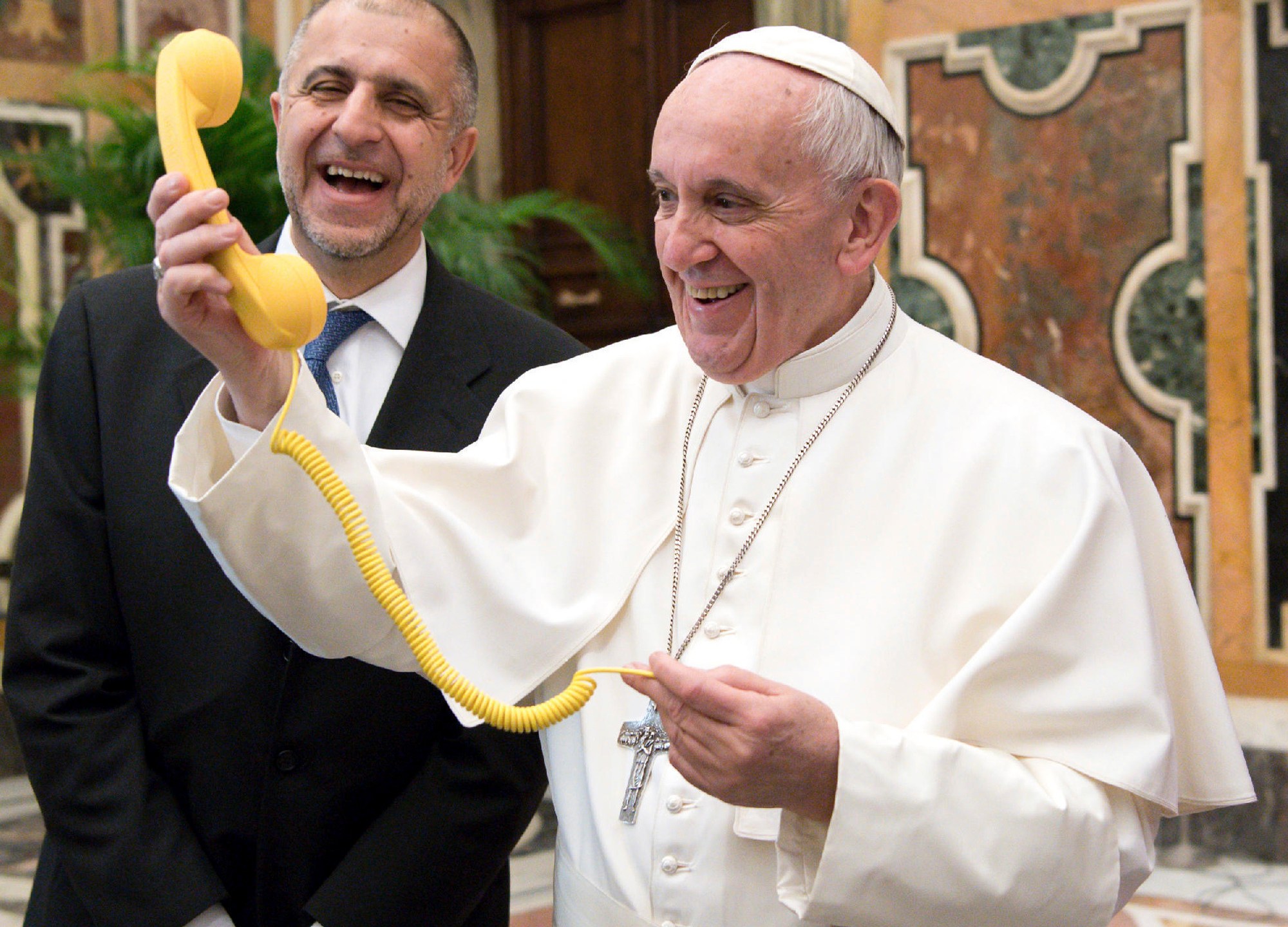 FILE - Pope Francis shares a light moment with "Telefono Amico" support hotline president Dario Briccola during an audience at the Vatican Saturday, March 11, 2017. (L'Osservatore Romano/Pool Photo via AP, File)