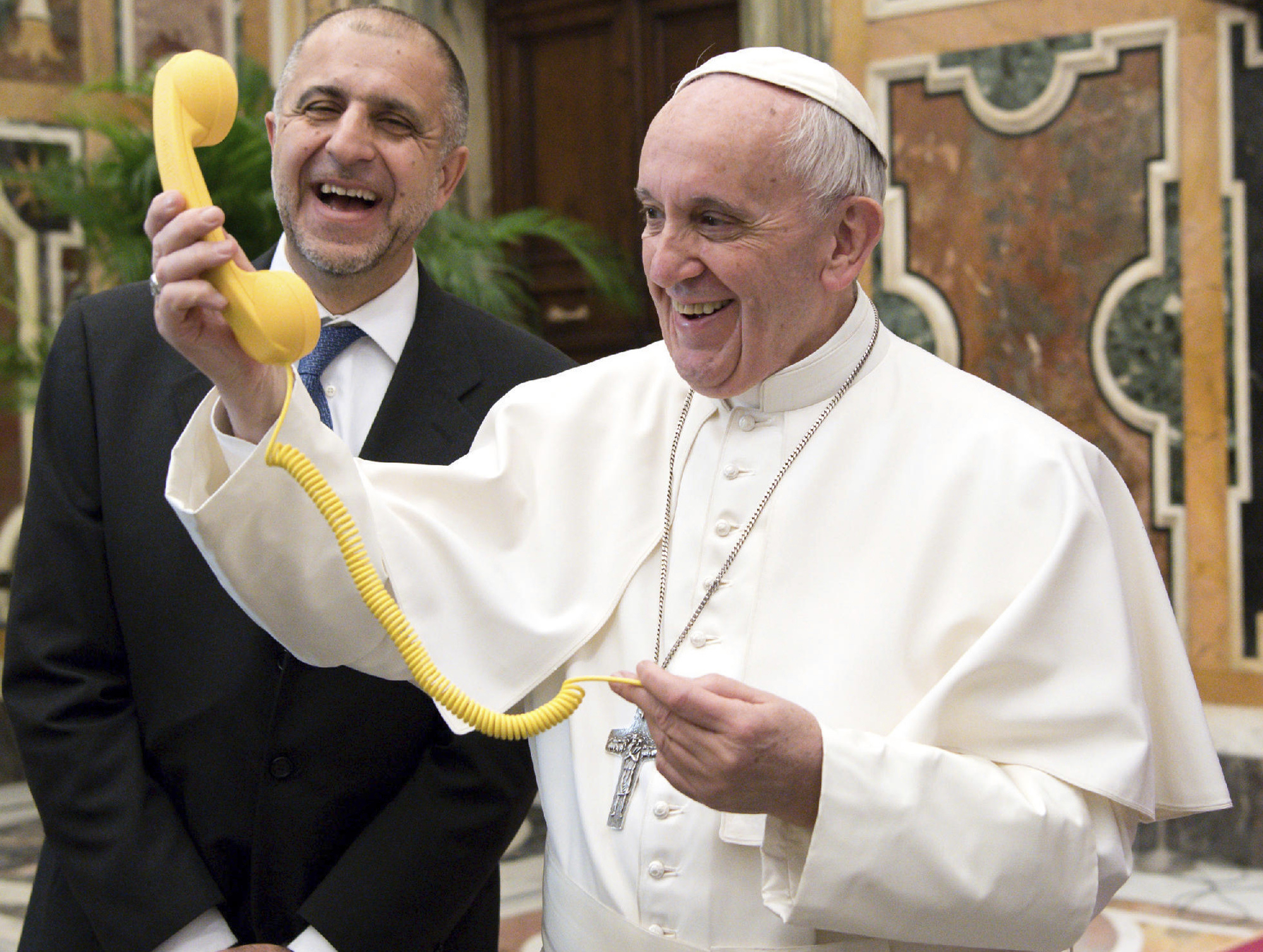 FILE - Pope Francis shares a light moment with "Telefono Amico" support hotline president Dario Briccola during an audience at the Vatican Saturday, March 11, 2017. (L'Osservatore Romano/Pool Photo via AP, File)