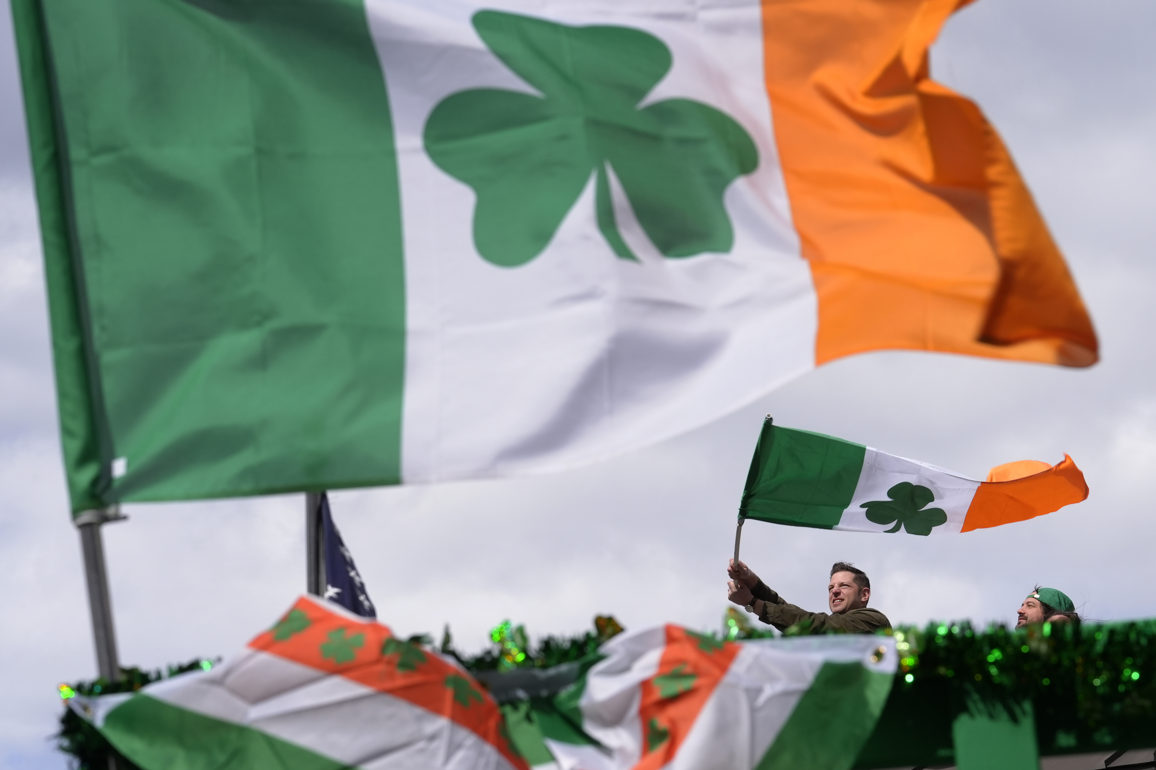 FILE - A person waves an Irish flag while watching the St. Patrick's Day parade, Sunday, March 17, 2024, in Boston's South Boston neighborhood. (AP Photo/Steven Senne, File)