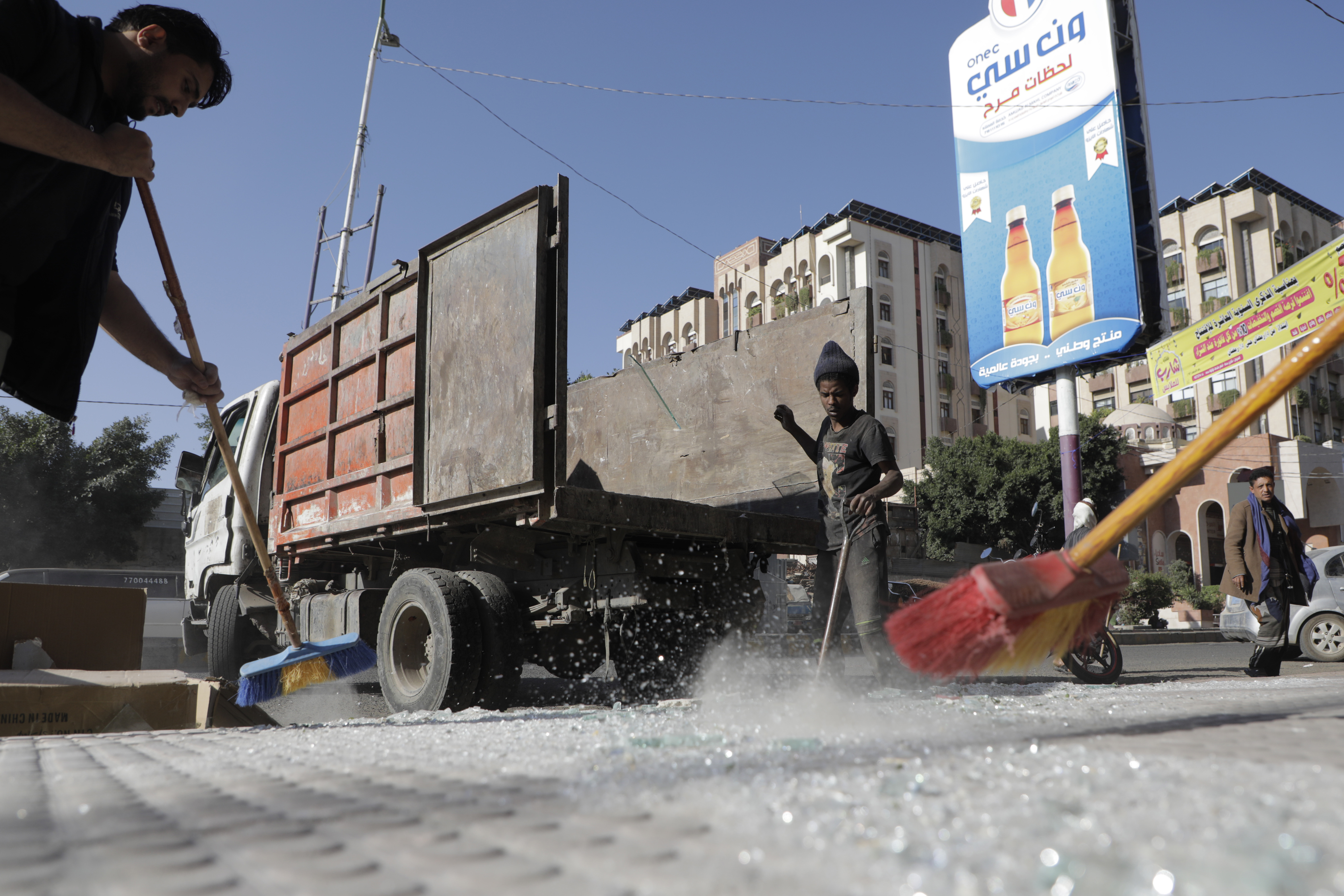 Yemenis clean debris in front of their shops after a U.S. airstrikes in Sanaa, Yemen, Sunday, March 16, 2025. (AP Photo/Osamah Abdulrahman)