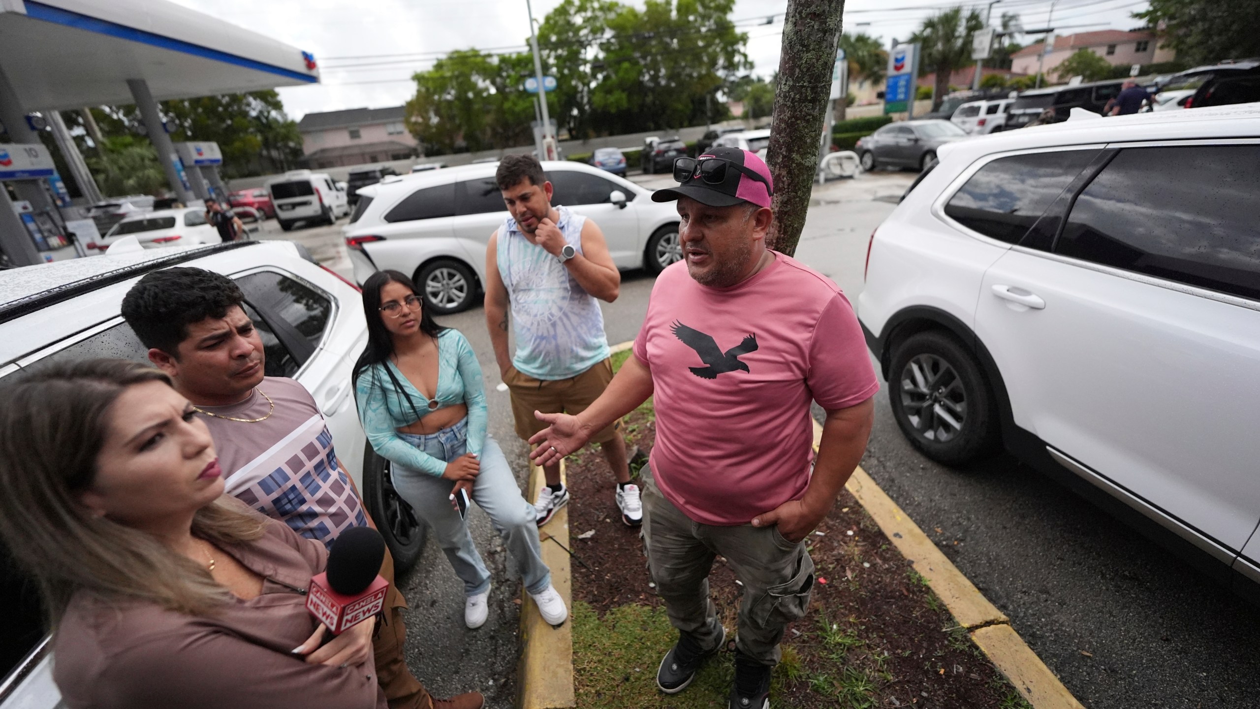 FILE - Henry Carmona, 48, right, who fled Venezuela after receiving death threats for refusing to participate in demonstrations in support of the government, stands with friends and a reporter following a press conference by Venezuelan community leaders to denounce changes to the protections that shielded hundreds of thousands of Venezuelans, including Carmona, from deportation, Monday, Feb. 3, 2025, in Doral, Fla. (AP Photo/Rebecca Blackwell, File)