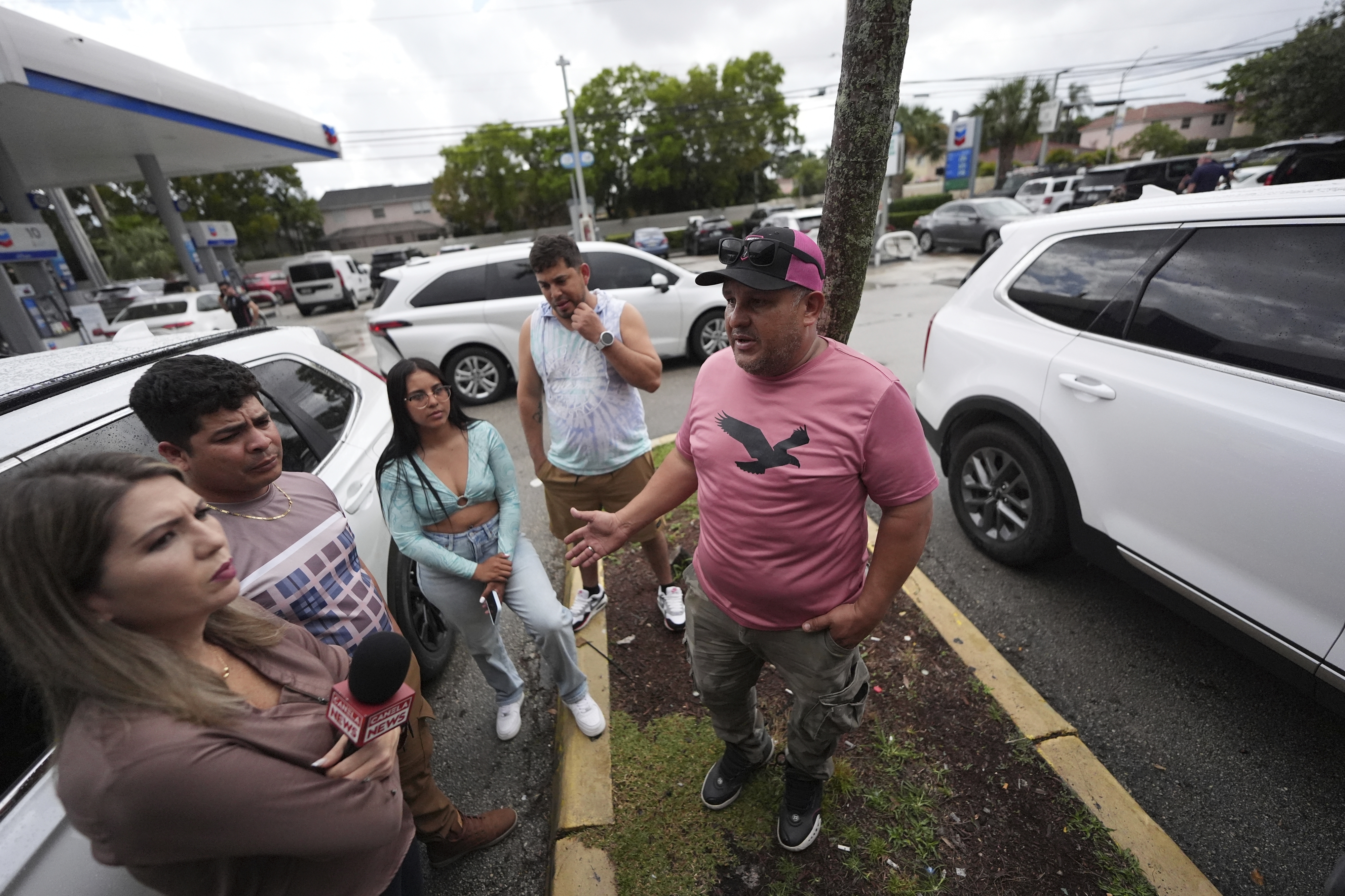 FILE - Henry Carmona, 48, right, who fled Venezuela after receiving death threats for refusing to participate in demonstrations in support of the government, stands with friends and a reporter following a press conference by Venezuelan community leaders to denounce changes to the protections that shielded hundreds of thousands of Venezuelans, including Carmona, from deportation, Monday, Feb. 3, 2025, in Doral, Fla. (AP Photo/Rebecca Blackwell, File)