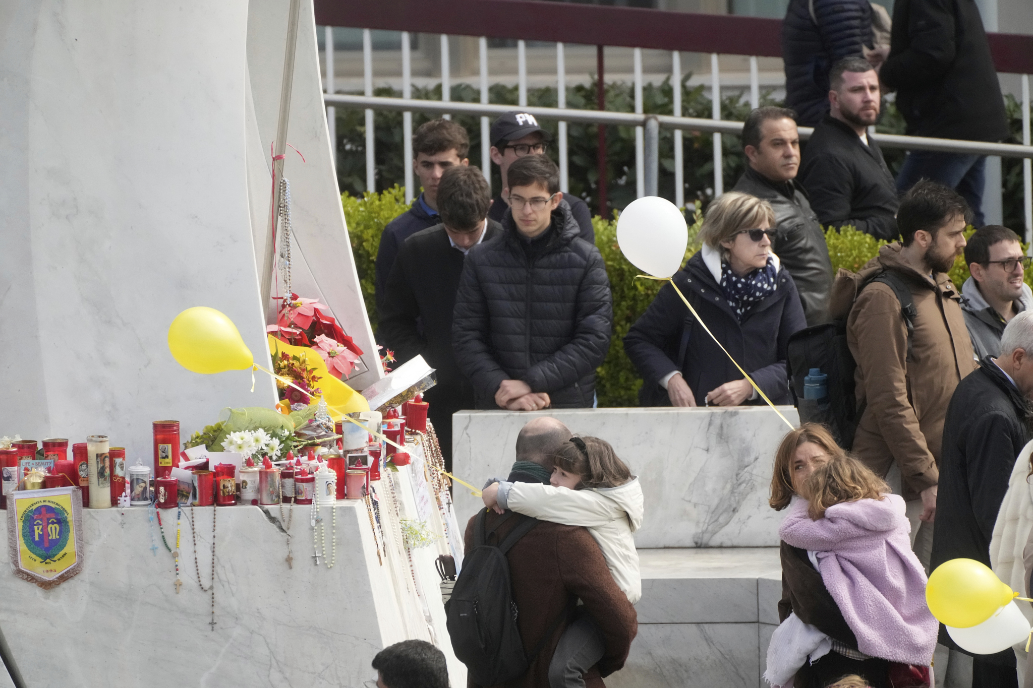 Faithful pray for Pope Francis outside the Agostino Gemelli polyclinic in Rome, Sunday, March 16, 2025. (AP Photo/Gregorio Borgia)