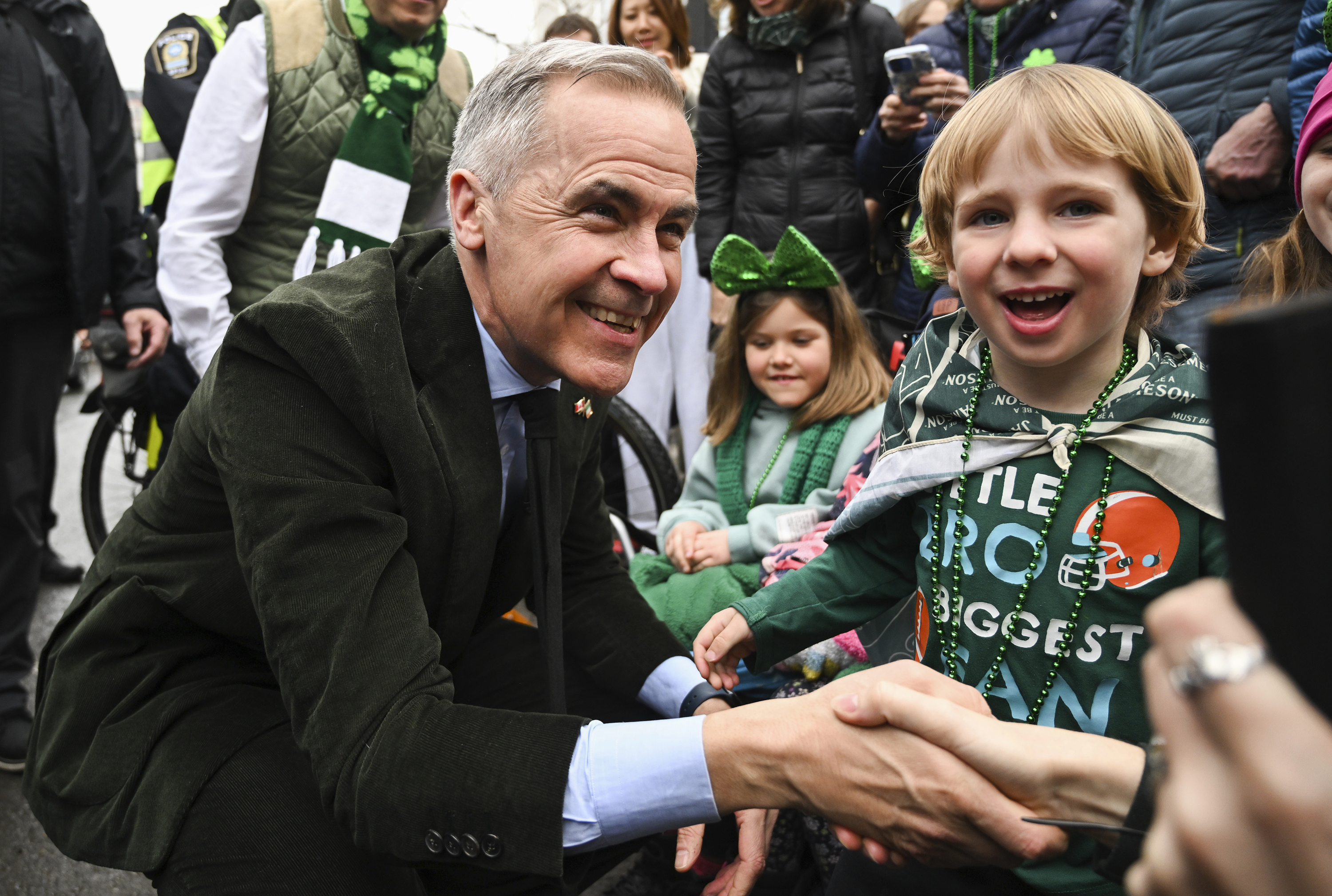 Prime Minister Mark Carney meets young members of the crowd during the annual St. Patrick's Day Parade in Montreal, Sunday March 16, 2025. (Graham Hughes /The Canadian Press via AP)