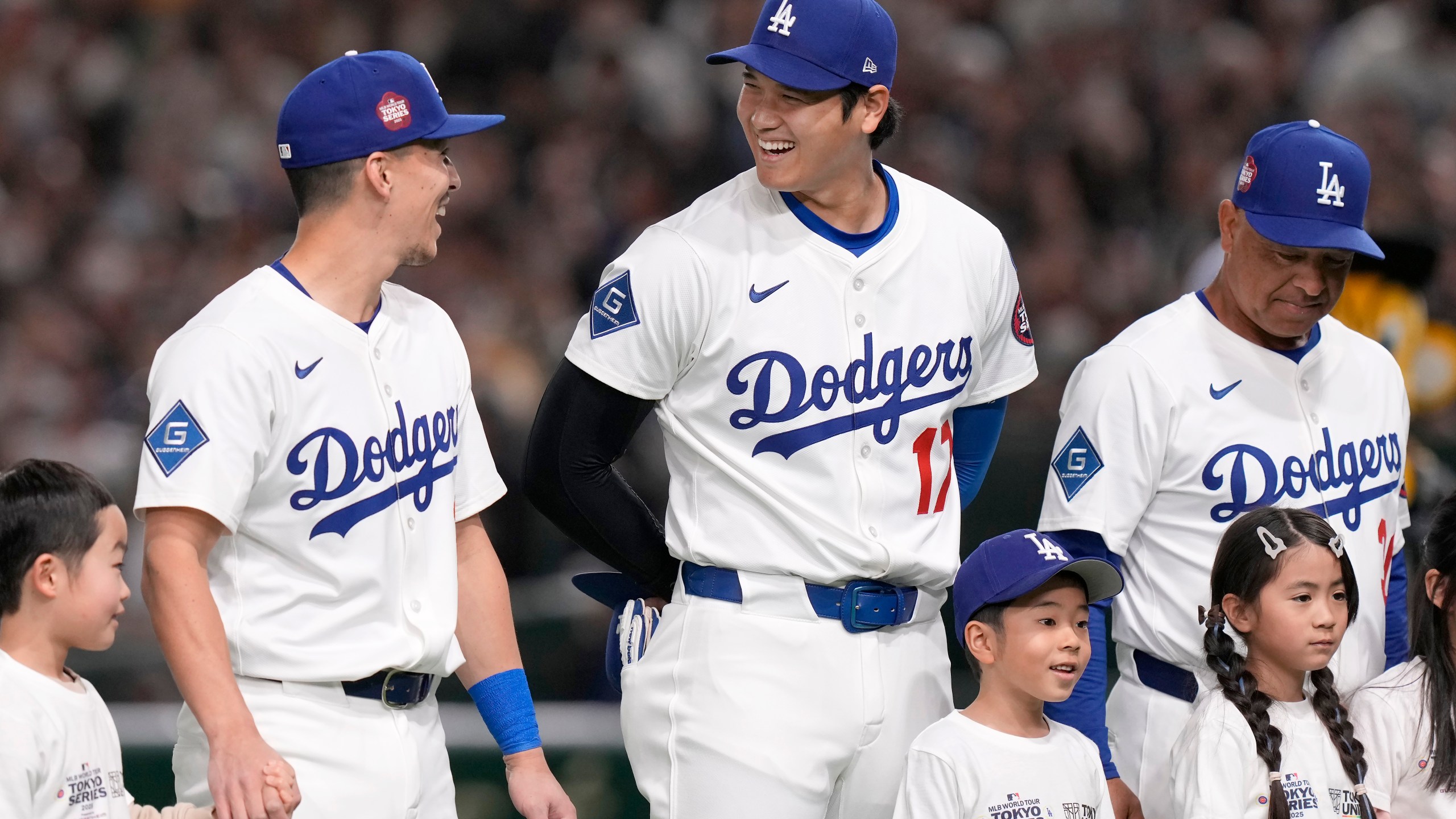 Los Angeles Dodgers' Tommy Edman, from top left, Shohei Ohtani (17) and manager Dave Roberts stand on the field before an MLB Japan Series exhibition baseball game against the Hanshin Tigers, Sunday, March 16, 2025, in Tokyo. (AP Photo/Eugene Hoshiko)