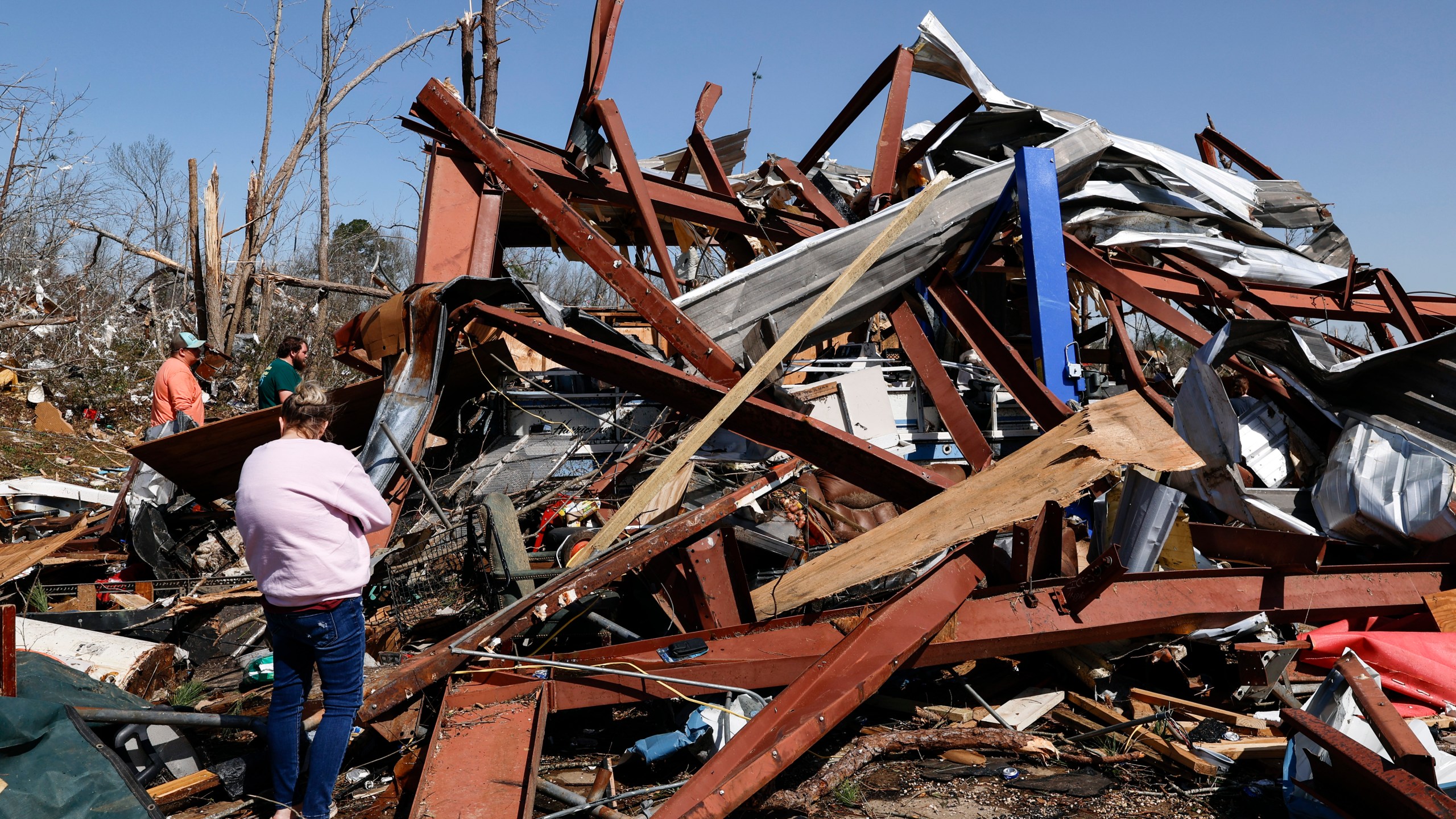 Friends and family members search for belongings in the damage after a tornado passed through the area, Sunday, March 16, 2025, in Plantersville, Ala. (AP Photo/Butch Dill)