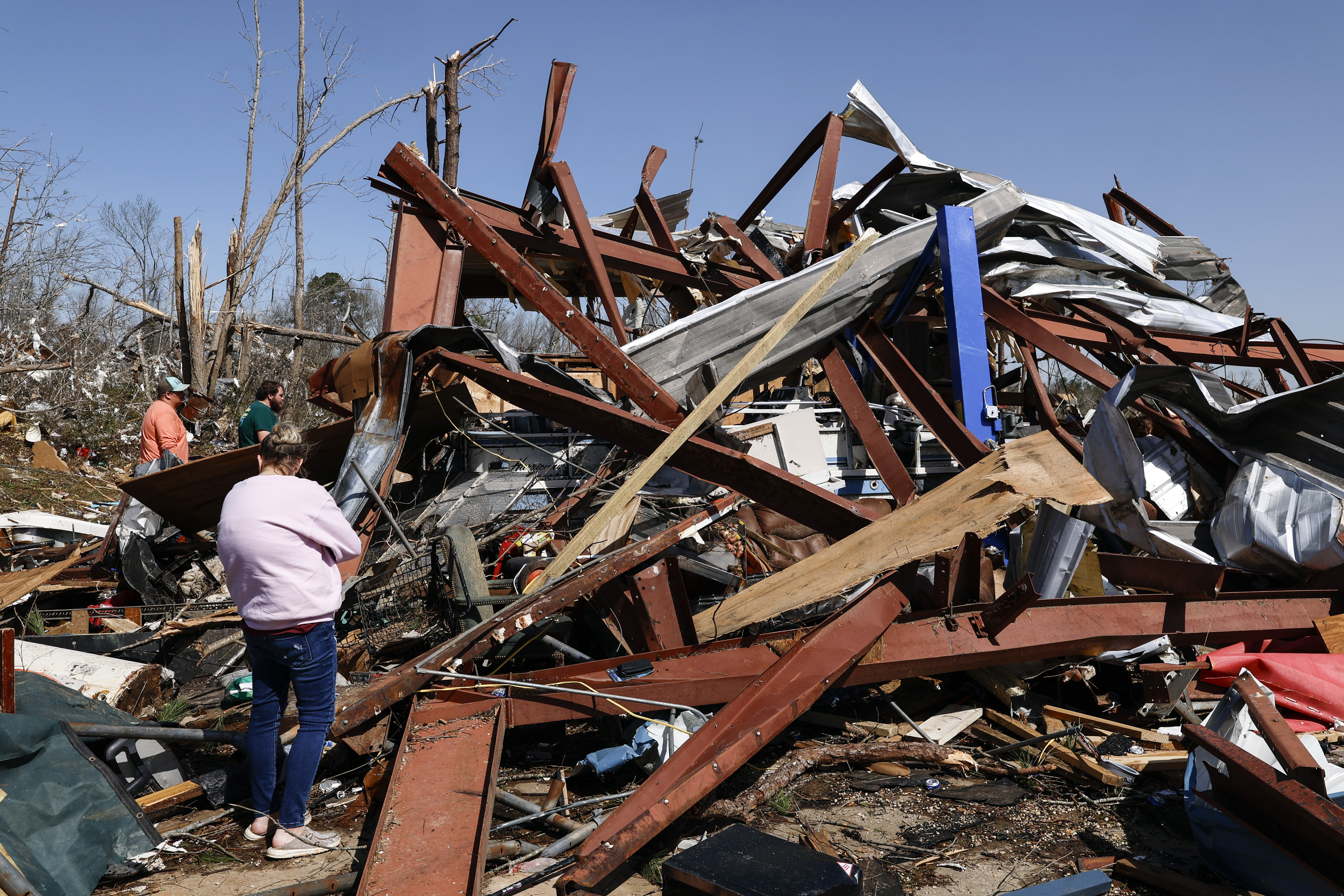 Friends and family members search for belongings in the damage after a tornado passed through the area, Sunday, March 16, 2025, in Plantersville, Ala. (AP Photo/Butch Dill)