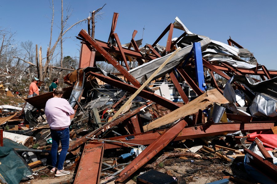 Friends and family members search for belongings in the damage after a tornado passed through the area, Sunday, March 16, 2025, in Plantersville, Ala. (AP Photo/Butch Dill)