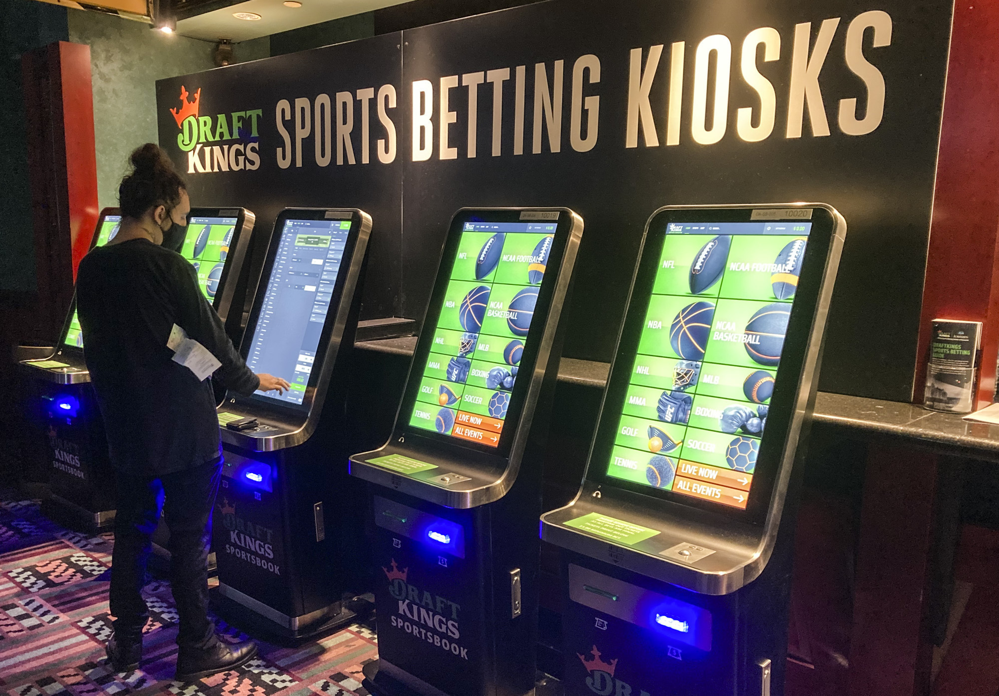 FILE - In this Thursday Sept. 30, 2021, file photo Zach Young, of New Haven, Conn., places a bet at one of the new sports wagering kiosks at Foxwoods Resort Casino in Mashantucket, Conn. (AP Photo/Susan Haigh, File)