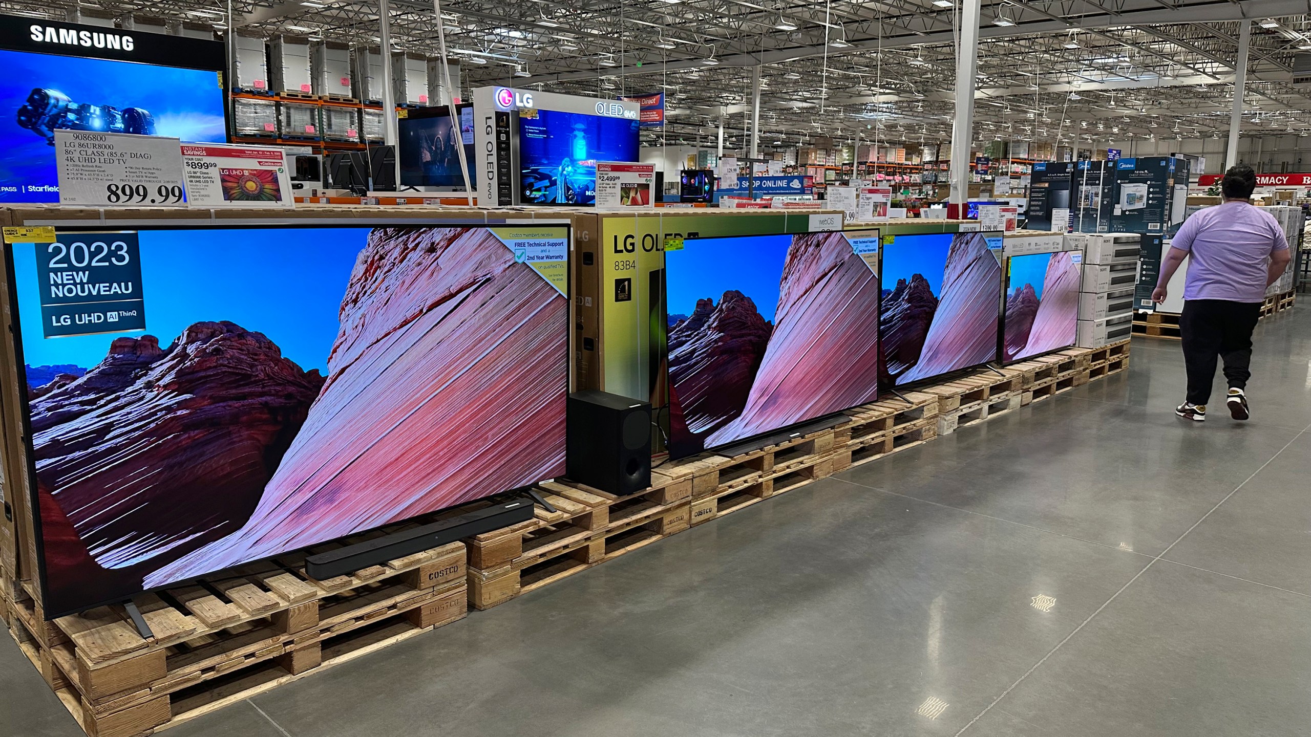 A shopper passes by a display of large-screen televisions in a Costco warehouse Monday, Feb. 3, 2025, in east Denver. (AP Photo/David Zalubowski)