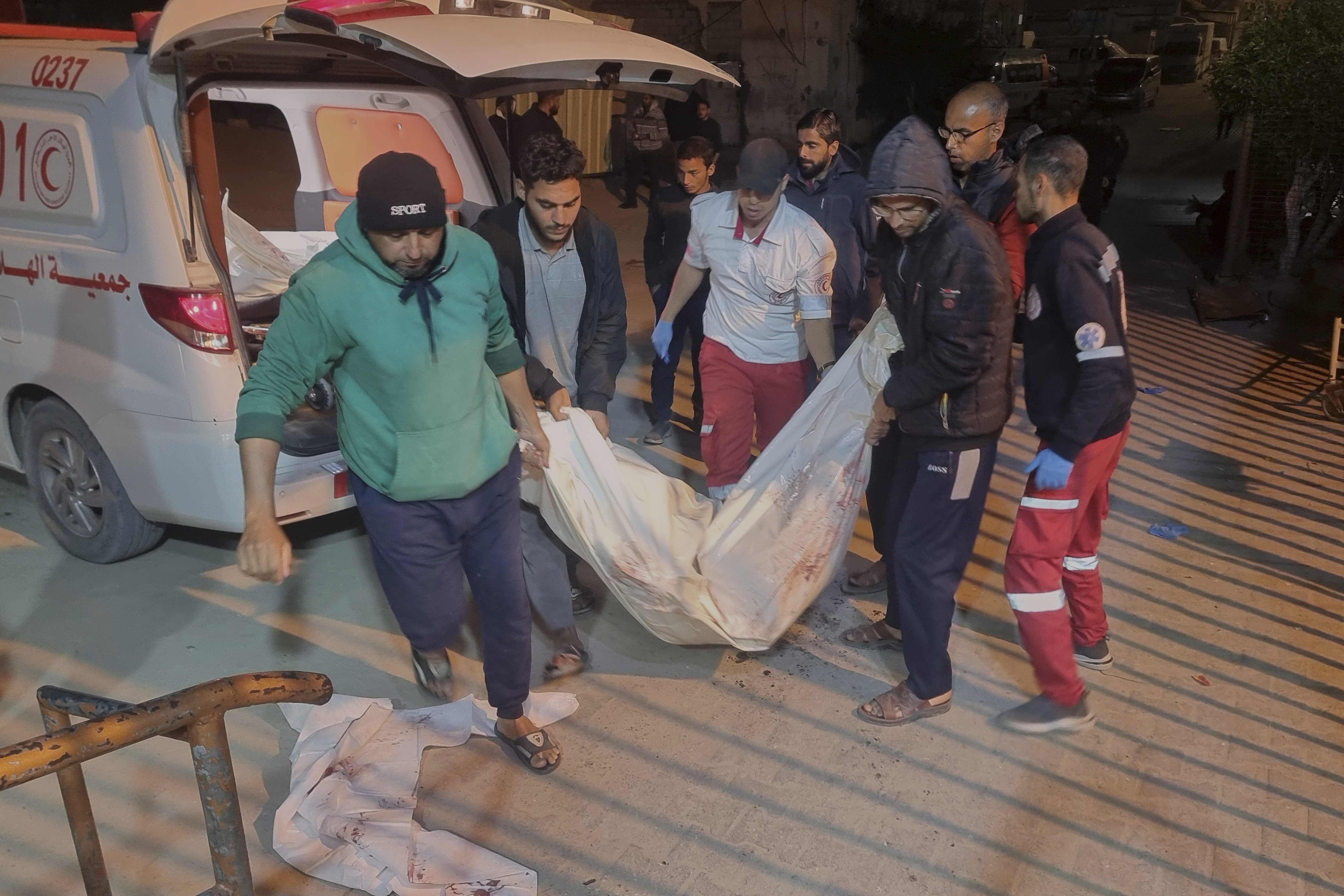 A dead person killed during an Israeli army strike is taken into the hospital in Khan Younis, southern Gaza Strip, Tuesday March 18, 2025.(AP Photo/ Mohammad Jahjouh)