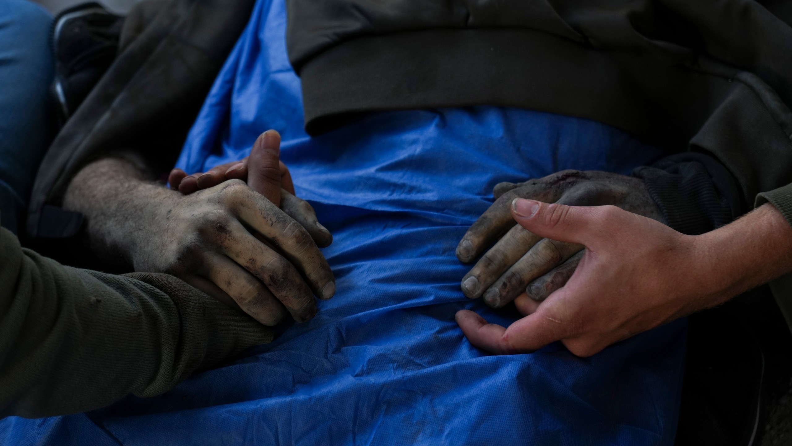 EDS NOTE: GRAPHIC CONTENT - EDS NOTE GRAPHIC CONTENT.- Palestinians hold the hands of their relative who was killed in an Israeli army airstrike, at Shifa Hospital in Gaza City, Tuesday, March 18, 2025. (AP Photo/Abdel Karem Hanna)