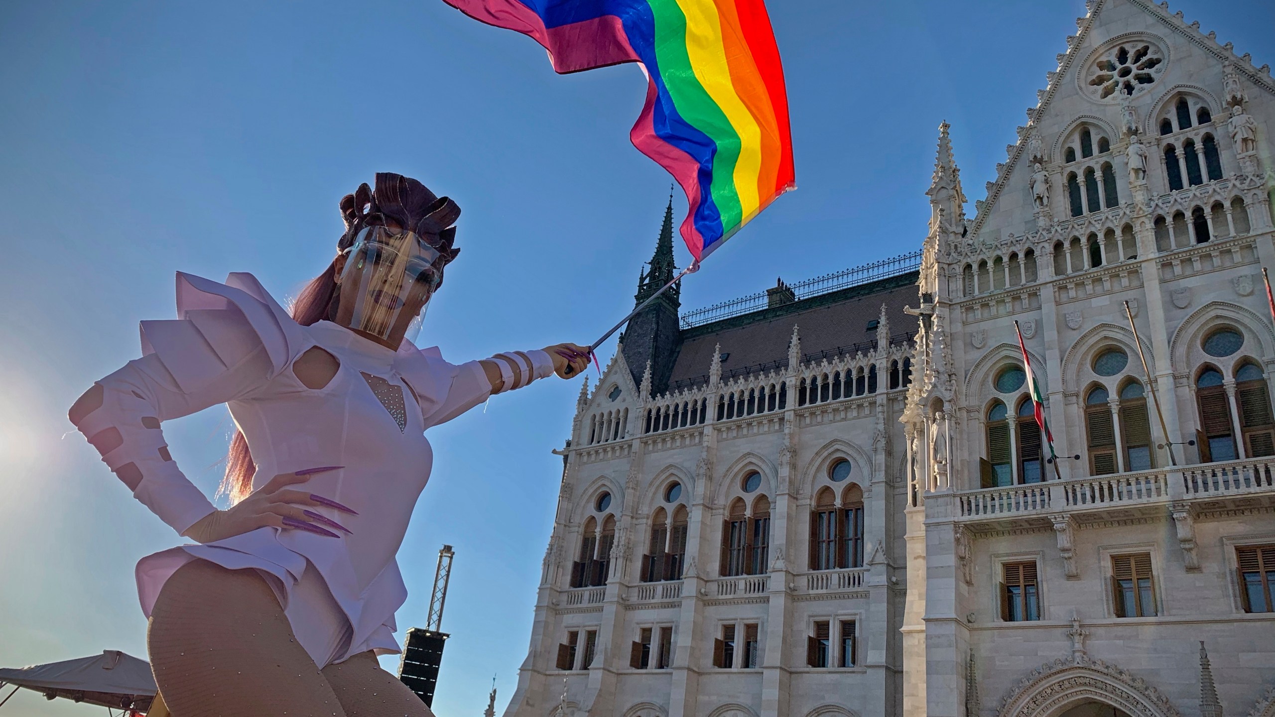 FILE - A participant waves a rainbow flag during an LGBT rights demonstration in front of the Hungarian Parliament building in Budapest, Hungary on June 14, 2021. (AP Photo/Bela Szandelszky, File)