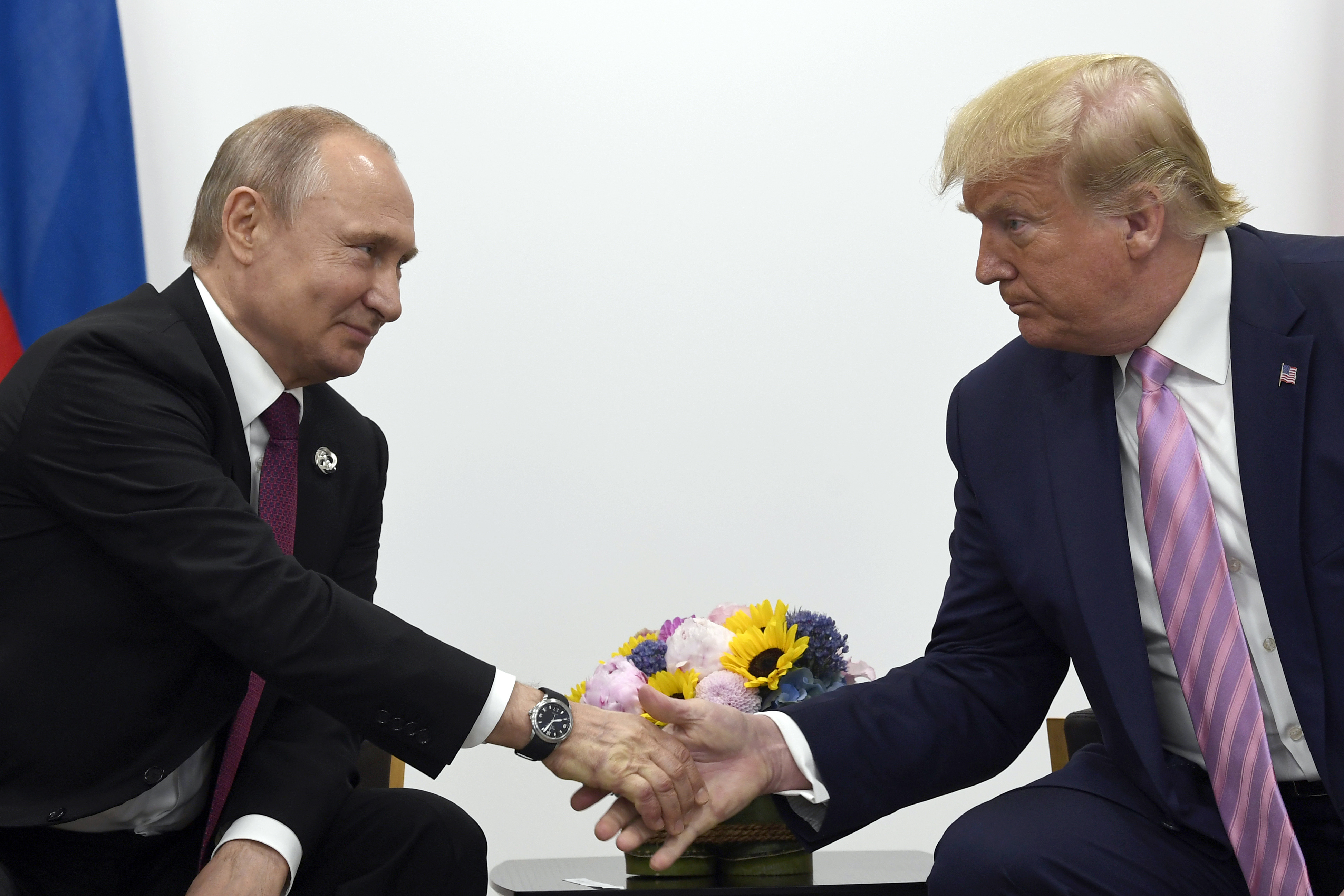 FILE - President Donald Trump, right, shakes hands with Russian President Vladimir Putin, left, during a bilateral meeting on the sidelines of the G-20 summit in Osaka, Japan, June 28, 2019. (AP Photo/Susan Walsh, File)