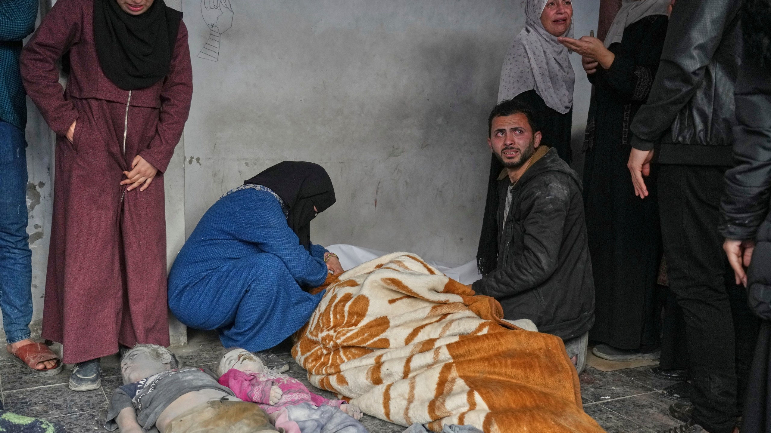 EDS NOTE GRAPHIC CONTENT.- A woman mourns over the body of a person killed in overnight Israeli army airstrikes across the Gaza Strip, at the Al-Ahli hospital in Gaza City, Tuesday, March 18, 2025. (AP Photo/Jehad Alshrafi)