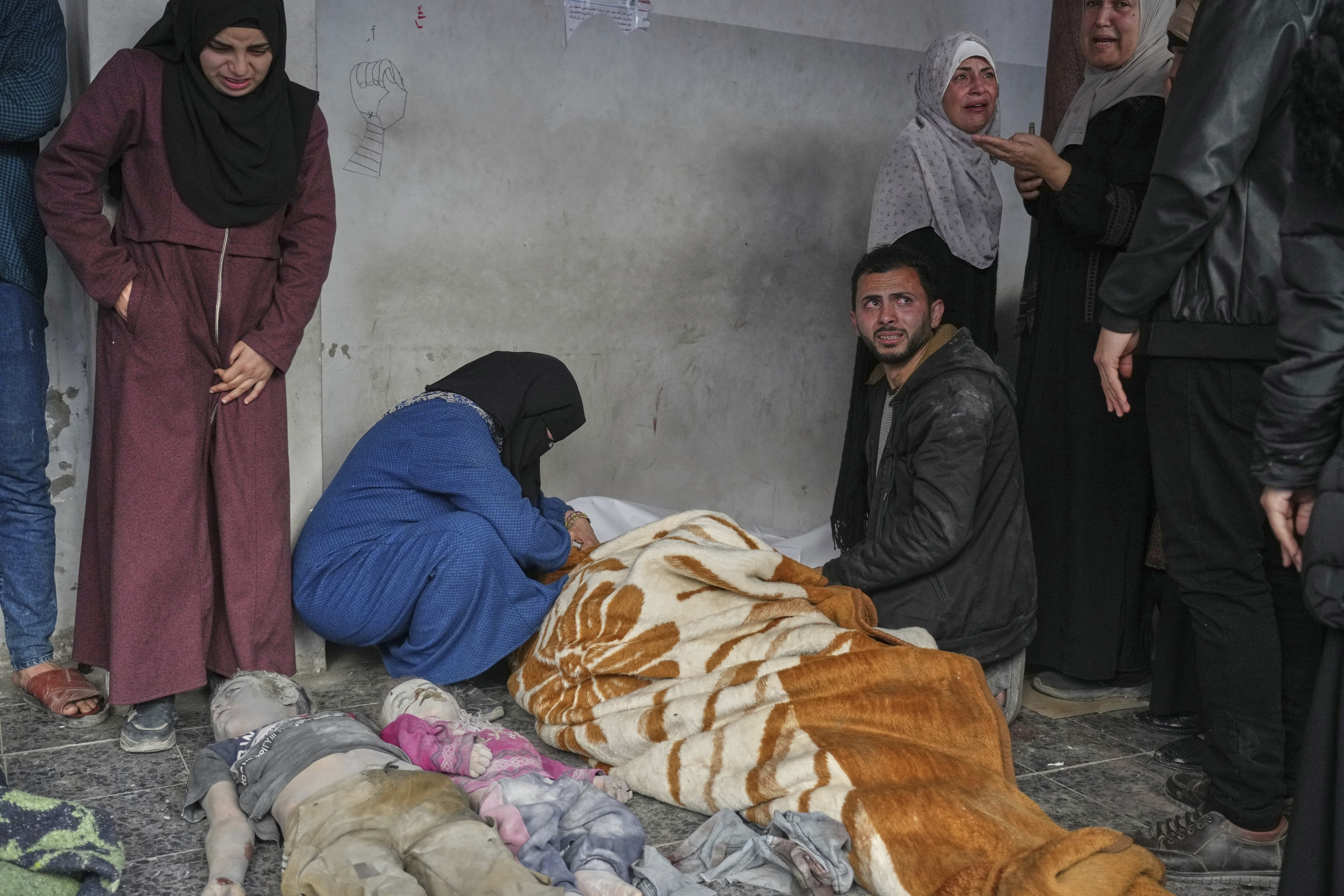 EDS NOTE GRAPHIC CONTENT.- A woman mourns over the body of a person killed in overnight Israeli army airstrikes across the Gaza Strip, at the Al-Ahli hospital in Gaza City, Tuesday, March 18, 2025. (AP Photo/Jehad Alshrafi)