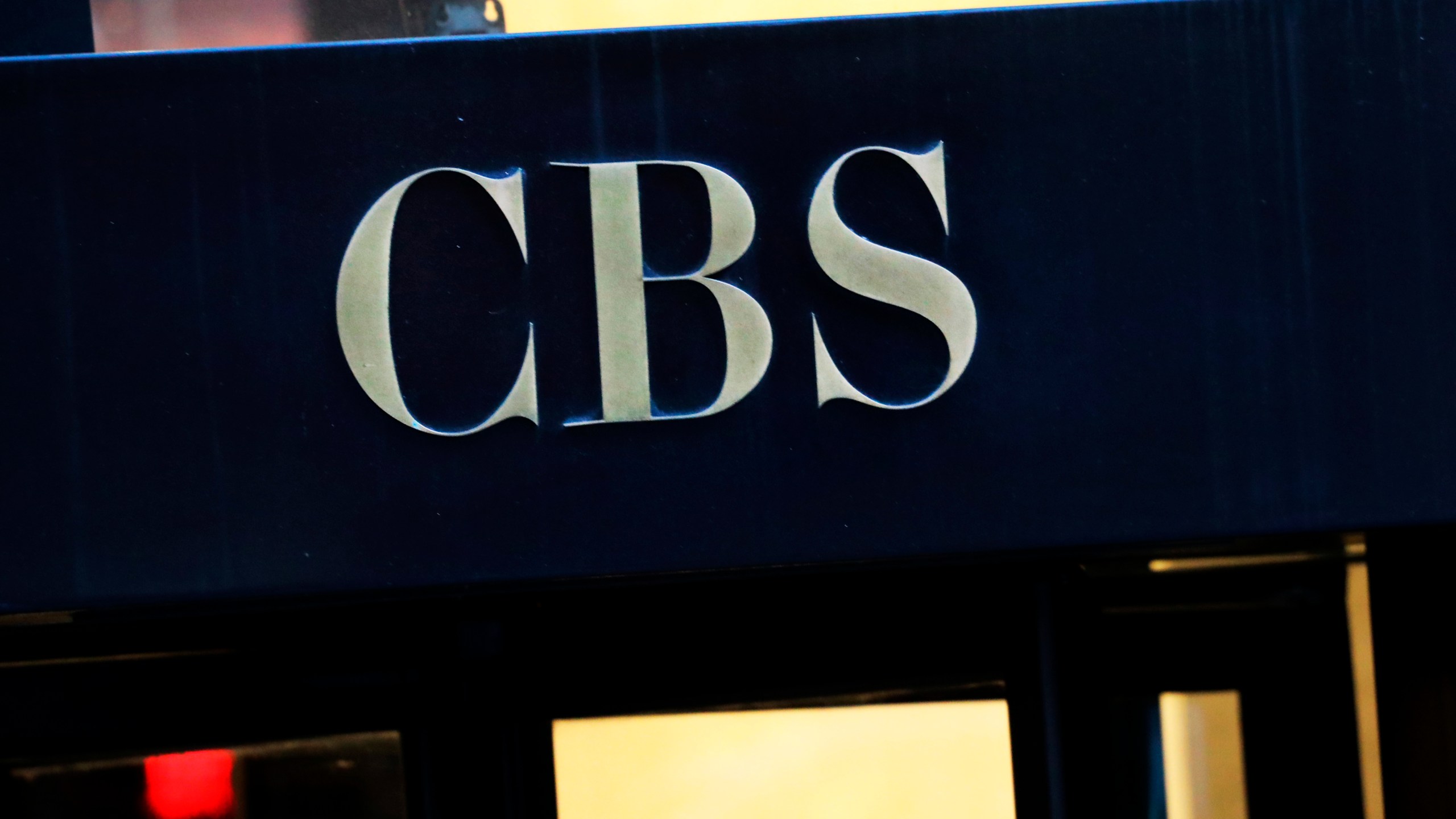 FILE - The CBS logo at the entrance to its headquarters, in New York Dec. 6, 2018. (AP Photo/Mark Lennihan, File)