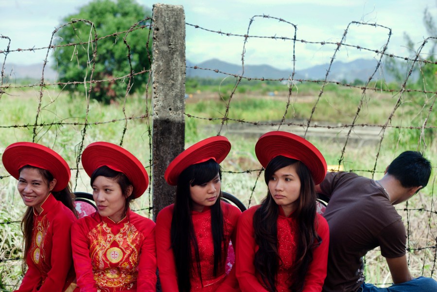 FILE- Attendants sit next to a field contaminated with dioxin before a ceremony marking the start of a project to clean up dioxin left over from the Vietnam War, at a former U.S. military base in Danang, Vietnam, Aug. 9, 2012. (AP Photo/Maika Elan, File)