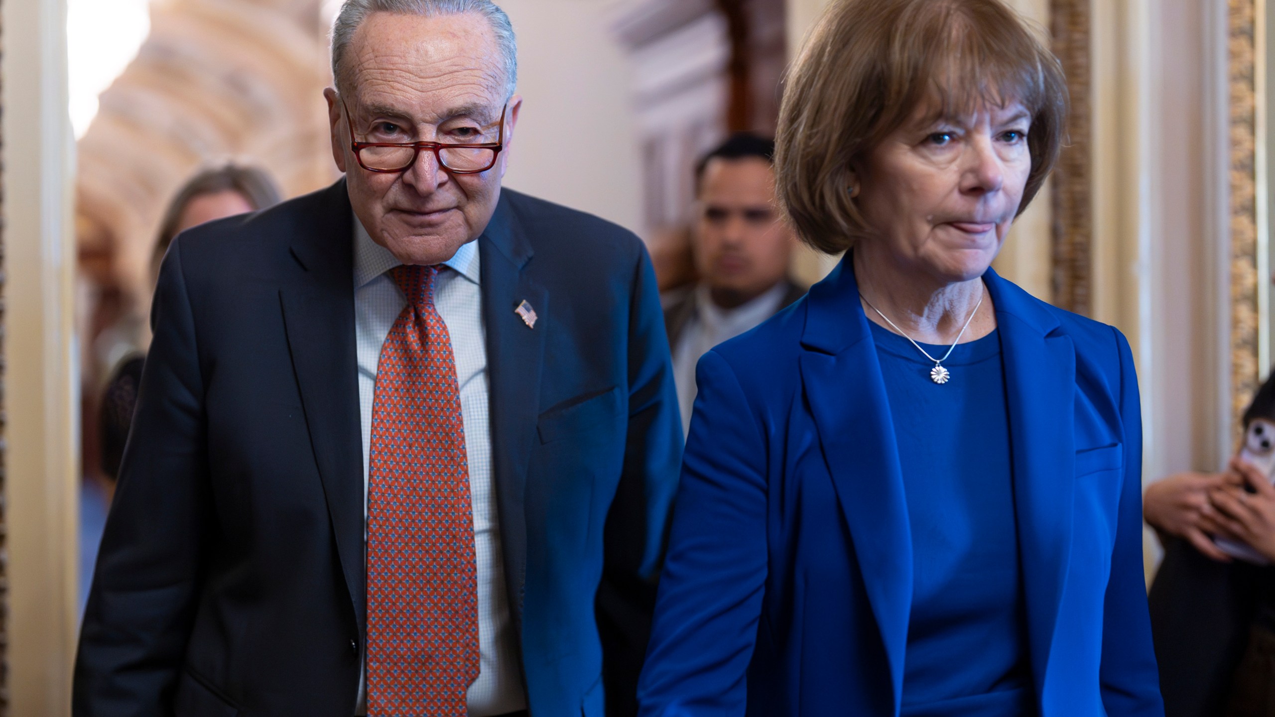 Senate Minority Leader Chuck Schumer, D-N.Y., walks with Sen. Tina Smith, D-Minn., right, as Senate Democrats gather behind closed doors to mount a last-ditch protest over a Republican-led spending bill that already passed the House, at the Capitol in Washington, Thursday, March 13, 2025. (AP Photo/J. Scott Applewhite)