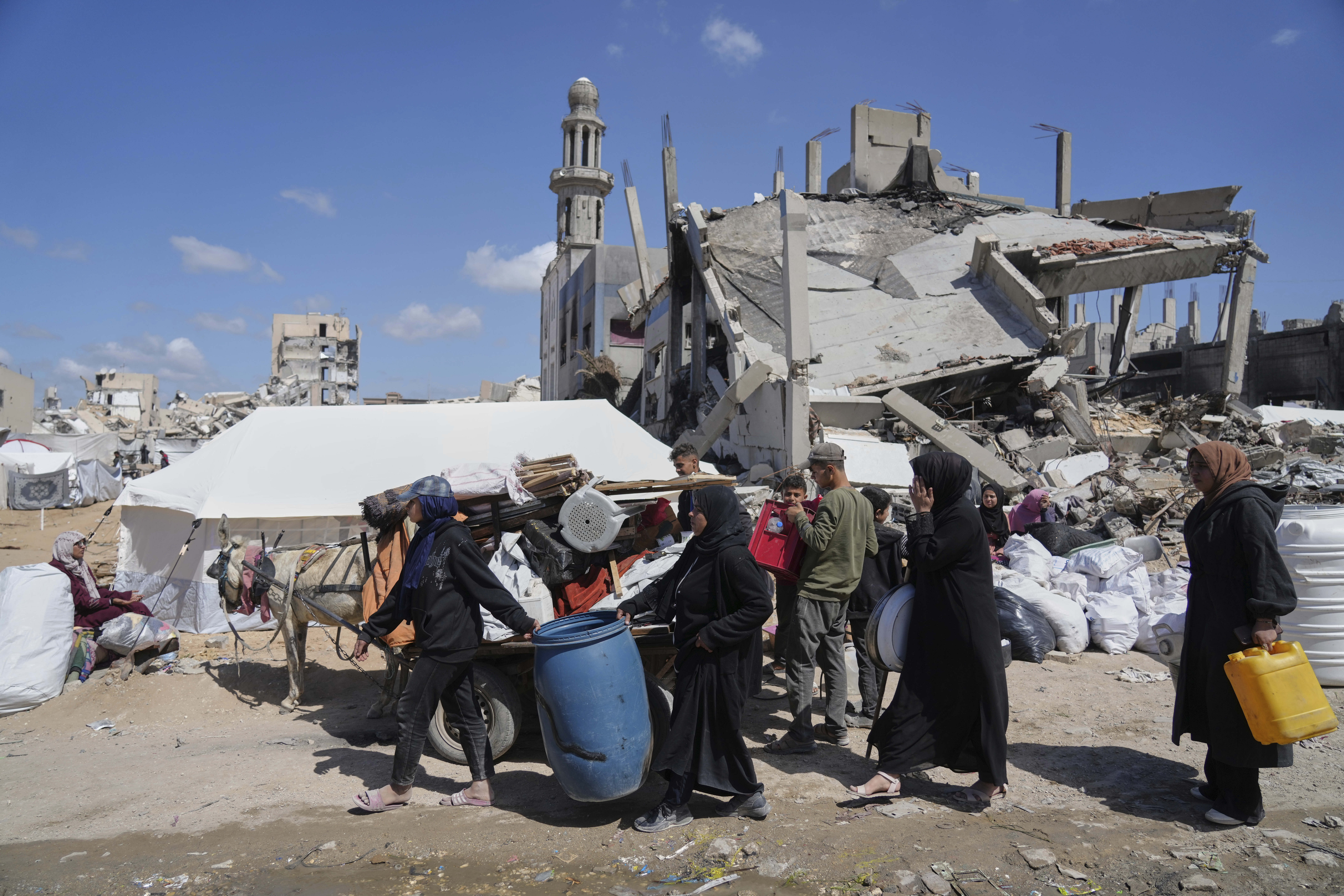 Displaced Palestinians, carrying their belongings traveling from Beit Hanoun to Jabaliya, a day after Israel's renewed offensive in the Gaza Strip, Wednesday, March 19, 2025. (AP Photo/Jehad Alshrafi)