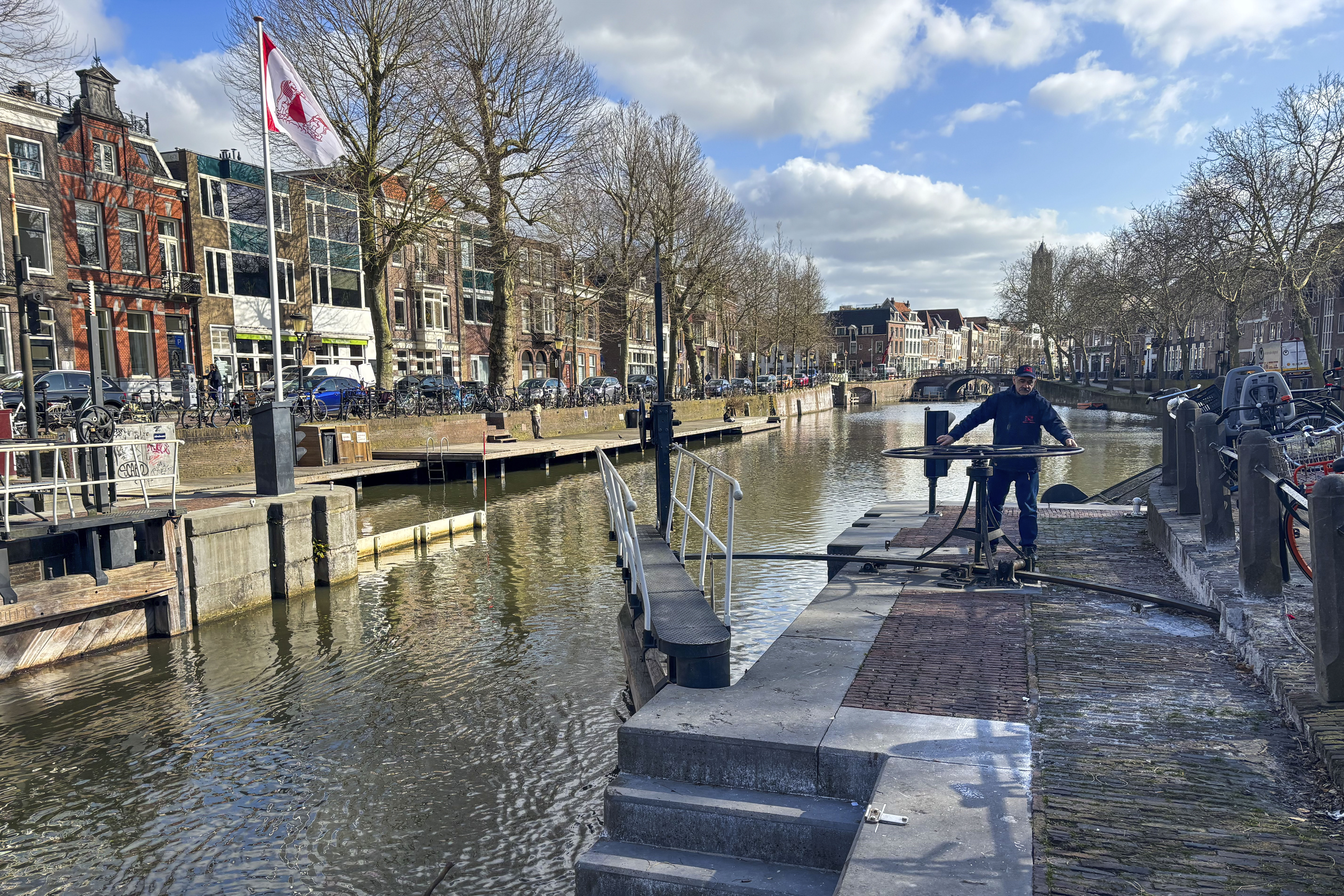 Rashid Ouchene opens the lock in Utrecht, Netherlands, Tuesday, March 11, 2025, where a "fish doorbell" was installed that lets viewers of an online livestream alert authorities to fish being held up as they make their springtime migration to shallow spawning grounds. (AP Photo/Aleksandar Furtula)