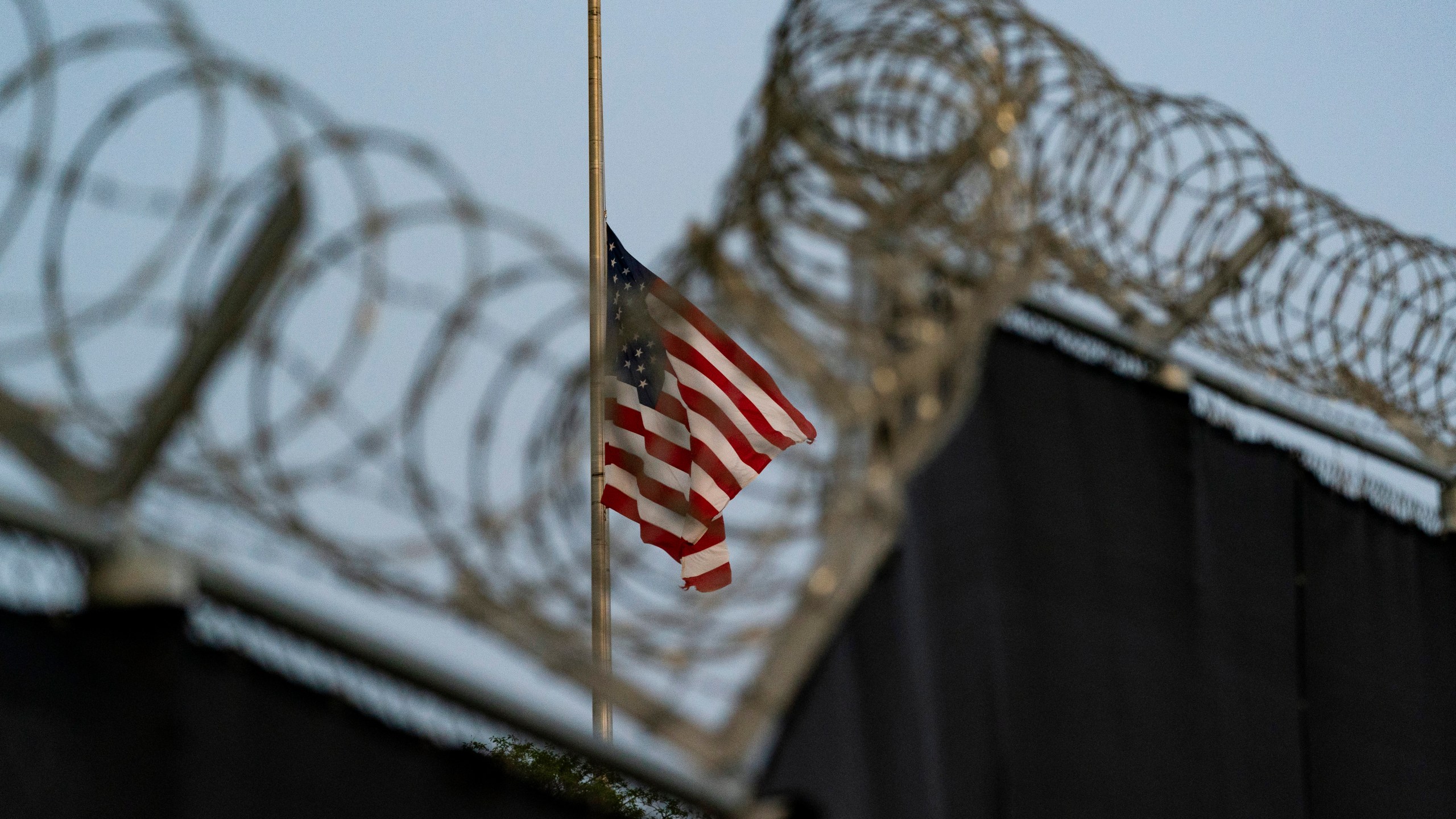 FILE - In this Aug. 29, 2021, file photo reviewed by U.S. military officials, a flag flies at half-staff as seen from Camp Justice in Guantanamo Bay Naval Base, Cuba. (AP Photo/Alex Brandon, File)