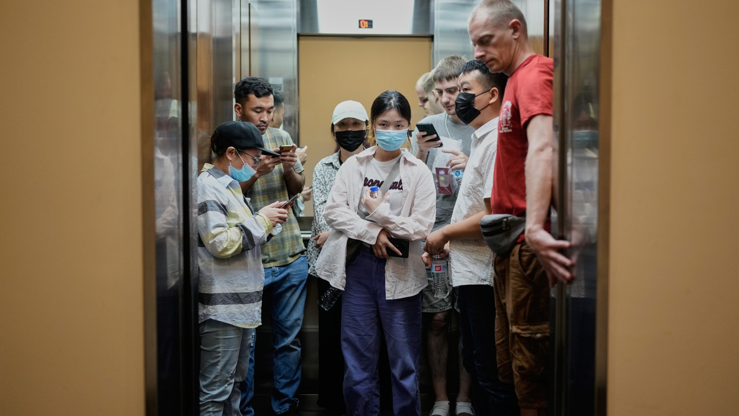 Migrants from Afghanistan, Russia and China, who were deported from the U.S., ride an elevator after visiting the Australian Consulate in Panama City, with the hope to start an asylum application process, Tuesday, March 18, 2025. (AP Photo/Matias Delacroix)