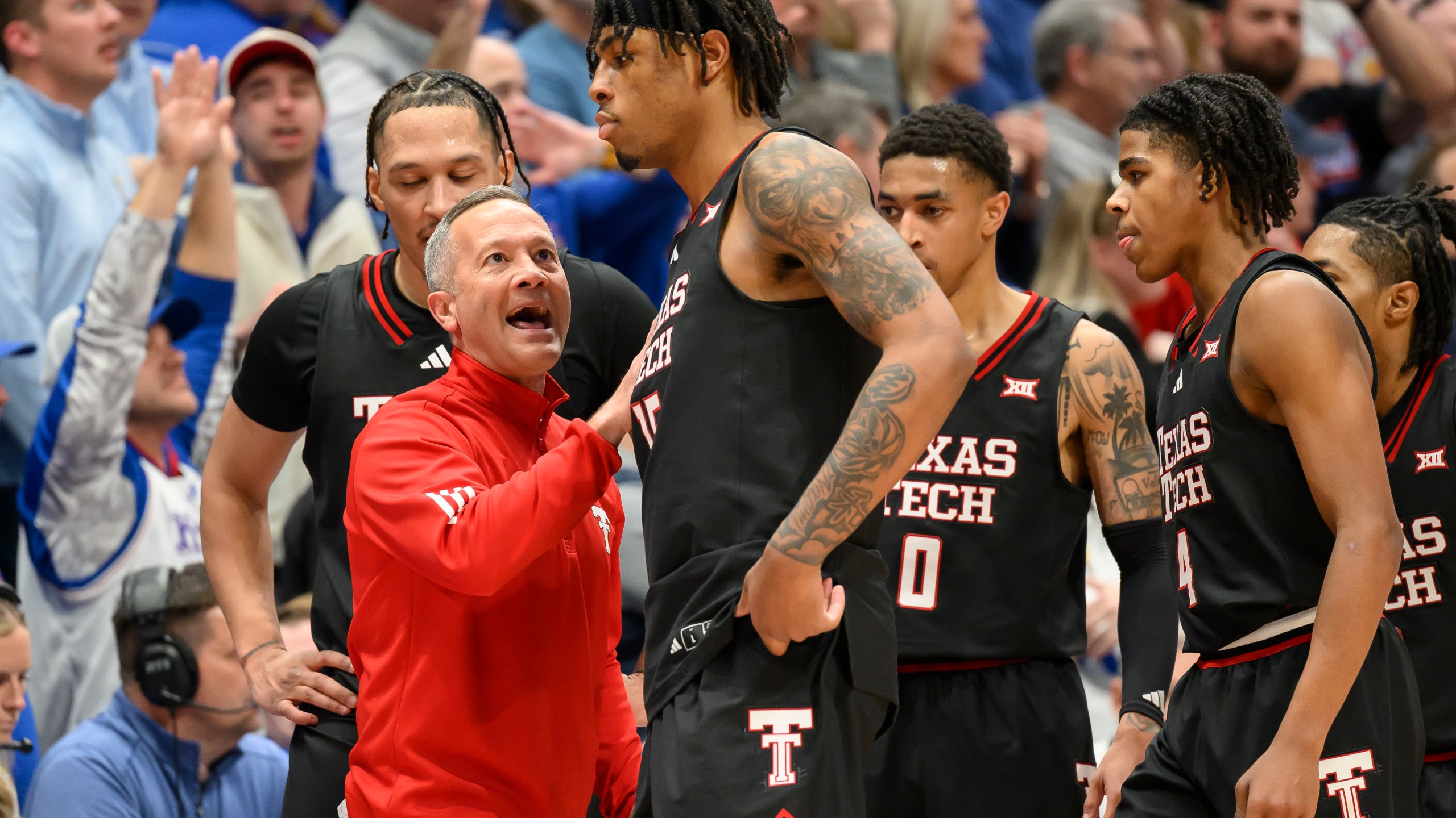 Texas Tech head coach Grant McCasland, left, talks to forward JT Toppin (15) after he fouled out against Kansas during the second half of an NCAA college basketball game in Lawrence, Kan., Saturday, March 1, 2025. (AP Photo/Reed Hoffmann)