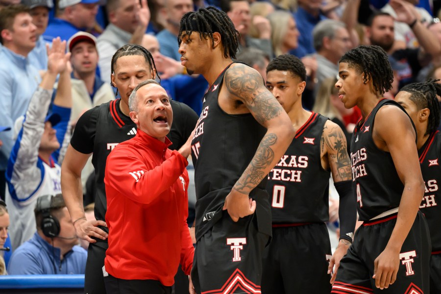 Texas Tech head coach Grant McCasland, left, talks to forward JT Toppin (15) after he fouled out against Kansas during the second half of an NCAA college basketball game in Lawrence, Kan., Saturday, March 1, 2025. (AP Photo/Reed Hoffmann)