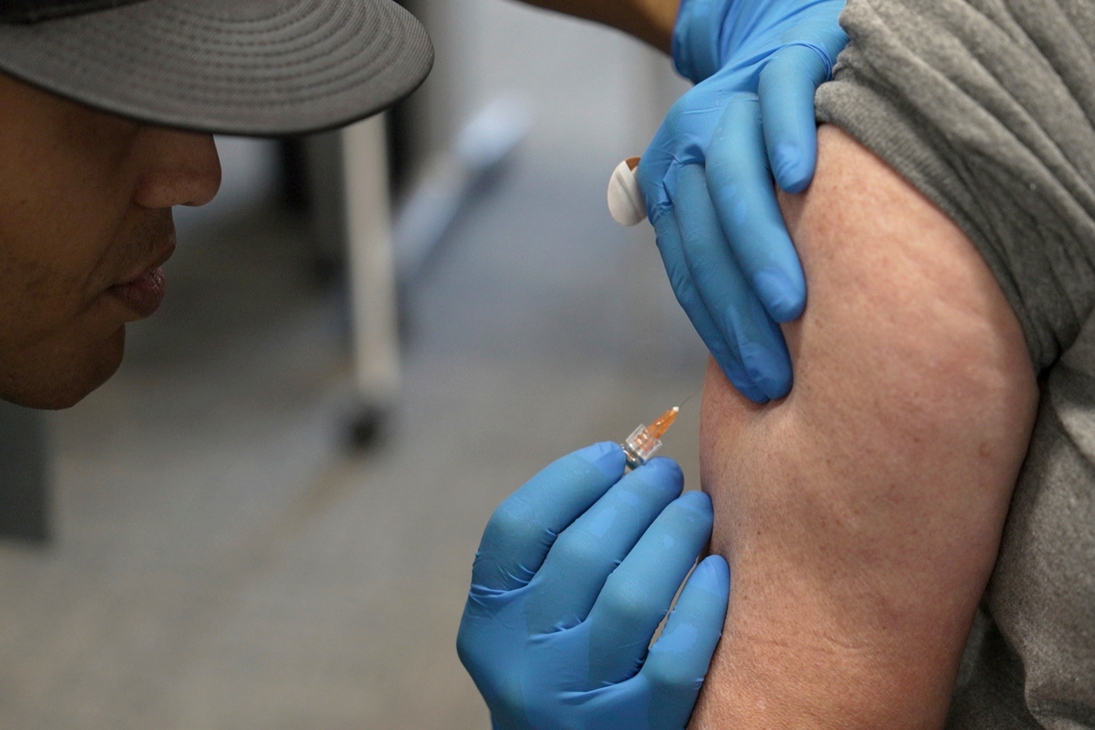 FILE - Matt Caldwell, left, a Lubbock Fire Department official, administers a measles, mumps and rubella vaccine to Clair May, 61, at the Lubbock Health Department, Feb. 26, 2025, in Lubbock, Texas. (AP Photo/Mary Conlon, File)