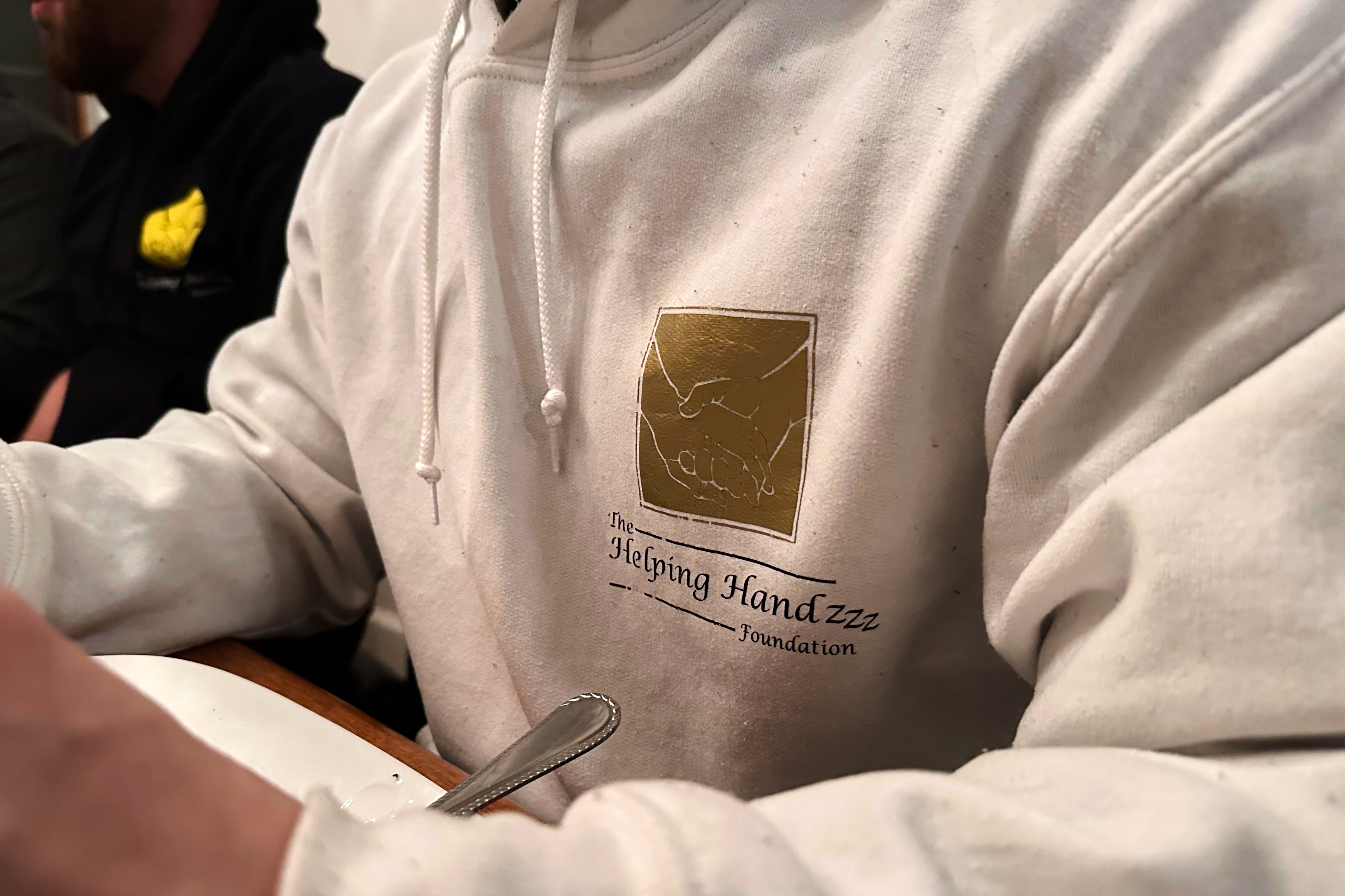 The Helping Handzzz Foundation board member Daoud Wehbi wears a branded sweatshirt during an iftar dinner Friday, March 7, 2025, in Dearborn, Mich. (AP Photo/Mike Householder)