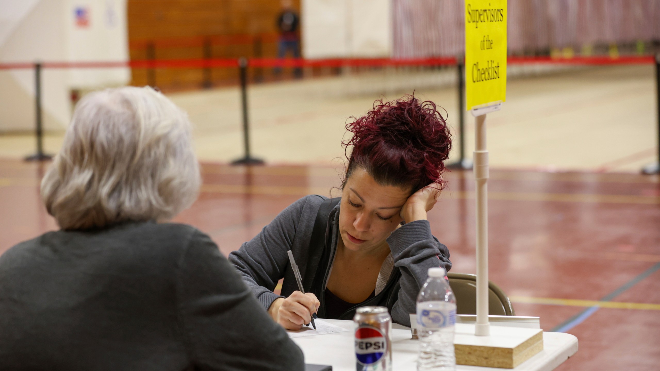 Brooke Younge registers to vote in Derry, N.H., Tuesday, March 11, 2025. (AP Photo/Reba Saldanha)