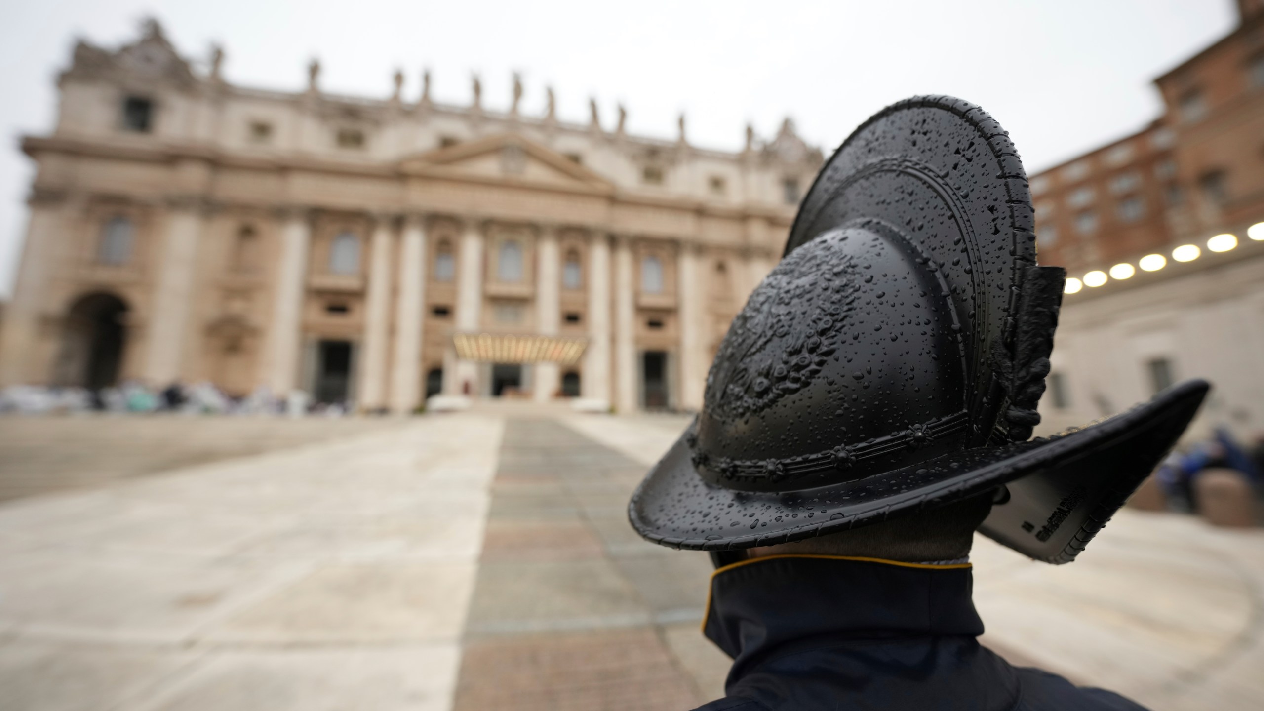 Pontifical Swiss Guards patrol during a mass for the jubilar pilgrims from Naples wait for the start of the celebration on a rainy day in St. Peter's Square at The Vatican, Saturday, March 22, 2025, while Pope Francis is being treated for bilateral pneumonia at Rome's Agostino Gemelli Polyclinic since Feb. 14. (AP Photo/Andrew Medichini)